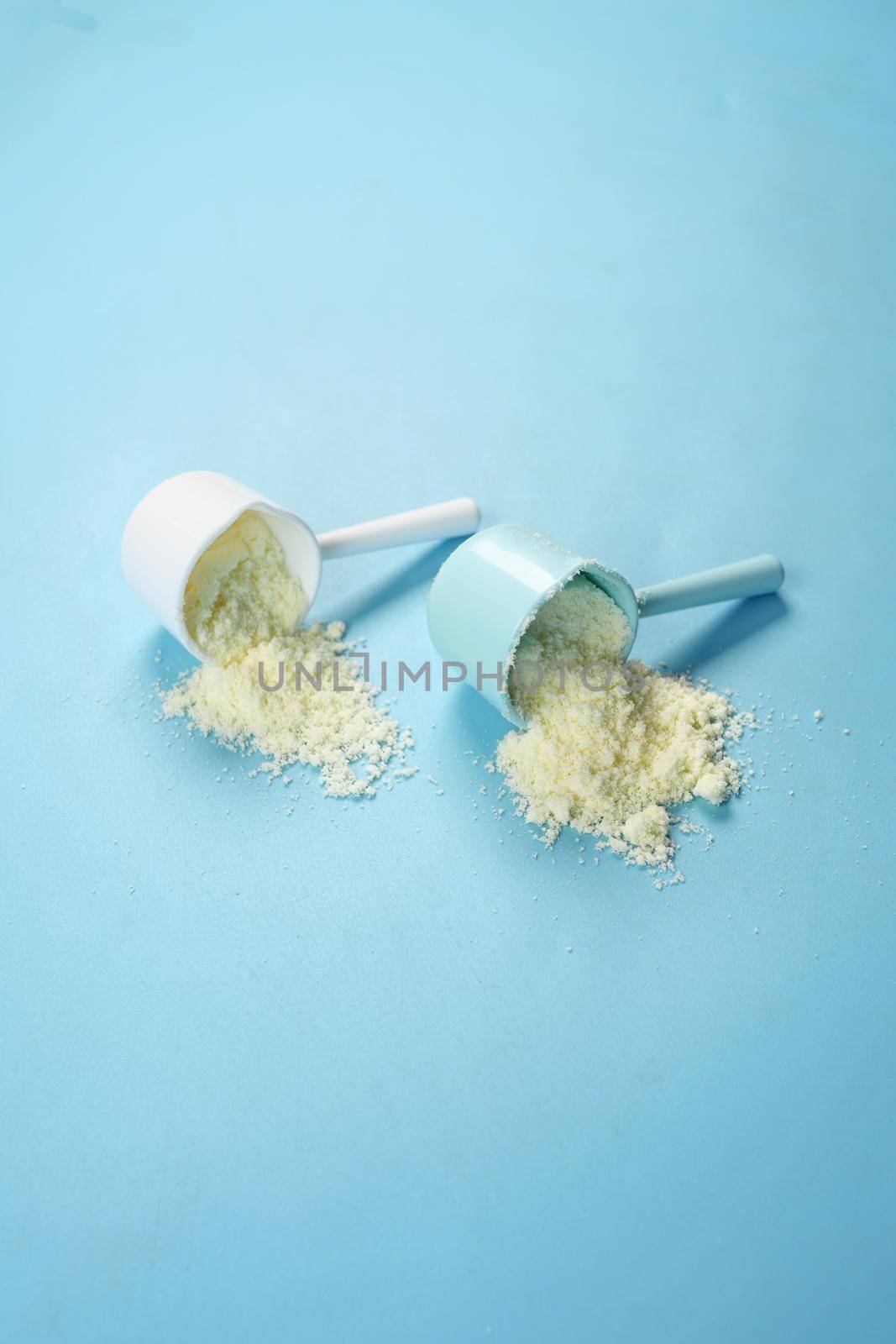 Close up of baby milk powder and spoon on tile background