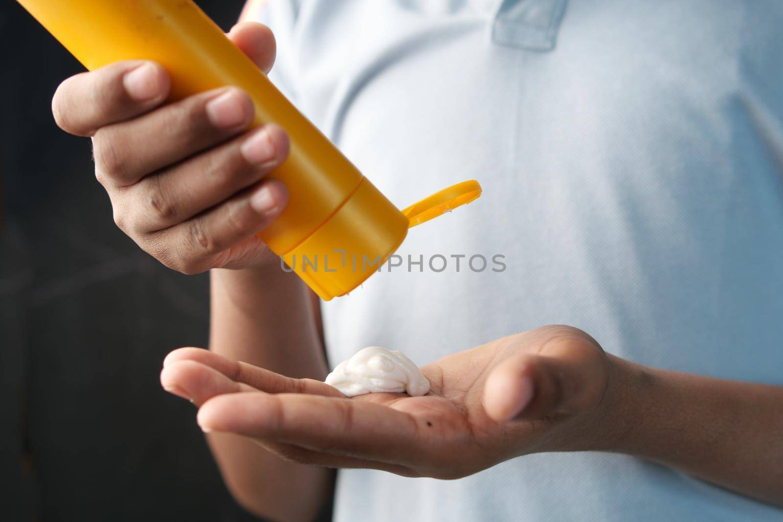 young men using sunscreen cream .