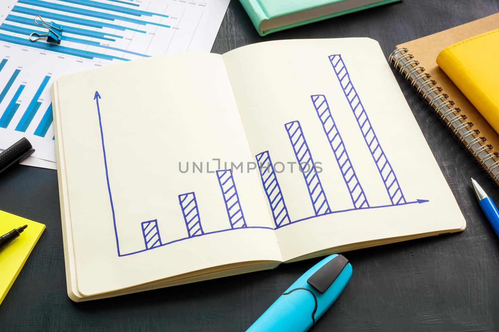 Increasing graph in notebook as a symbol of business success.