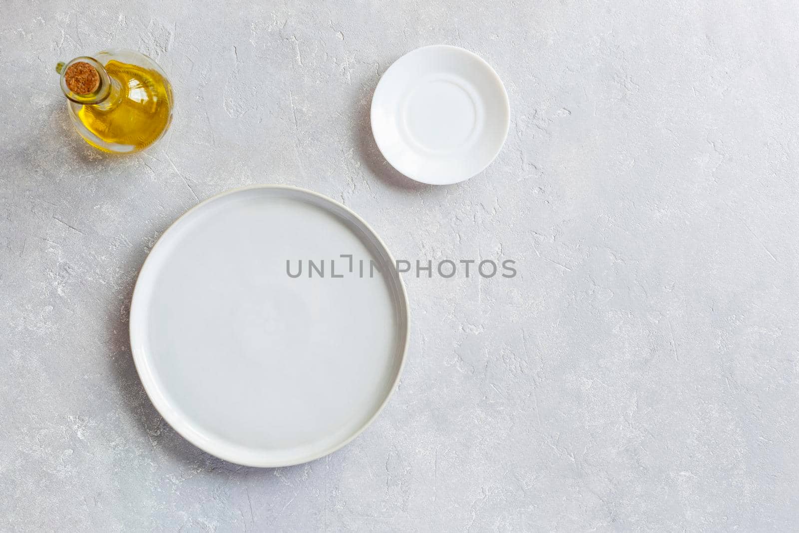 mockup white empty serving dish, small plate and olive oil pitcher, top view, copy space