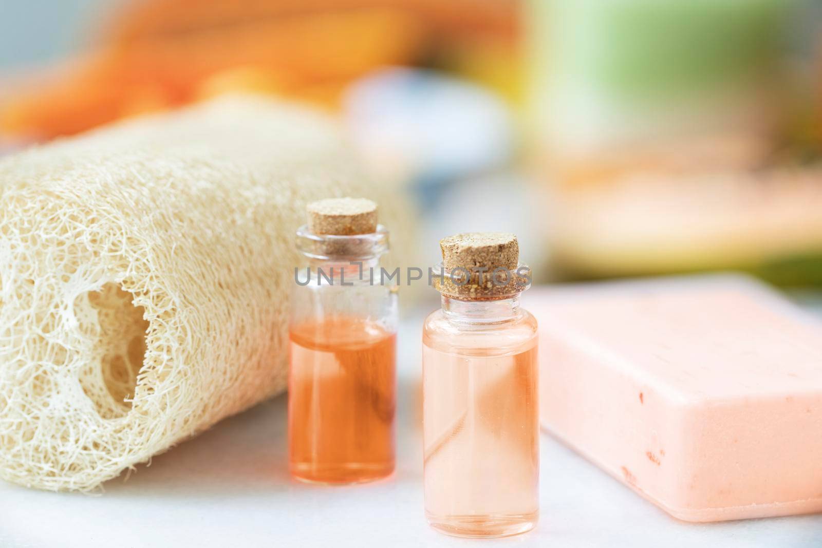 Two small bottles of fruit extracts with soap and loofa sponge.