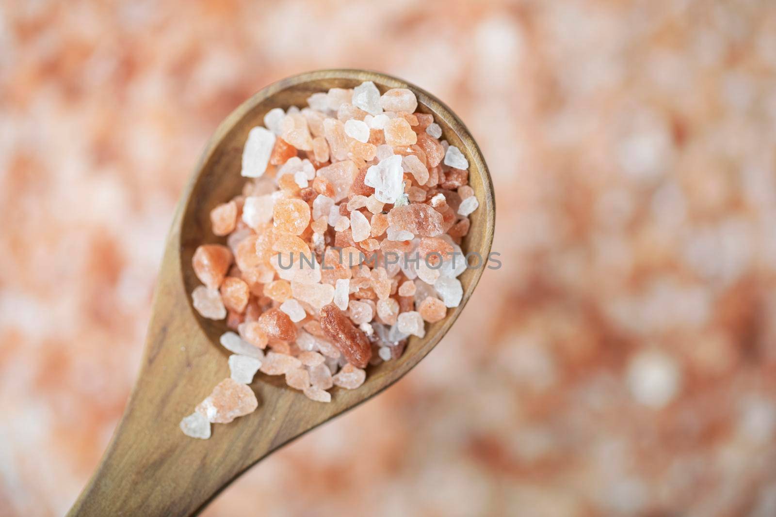 Pink Himalyan salt in wooden spoon, flat lay