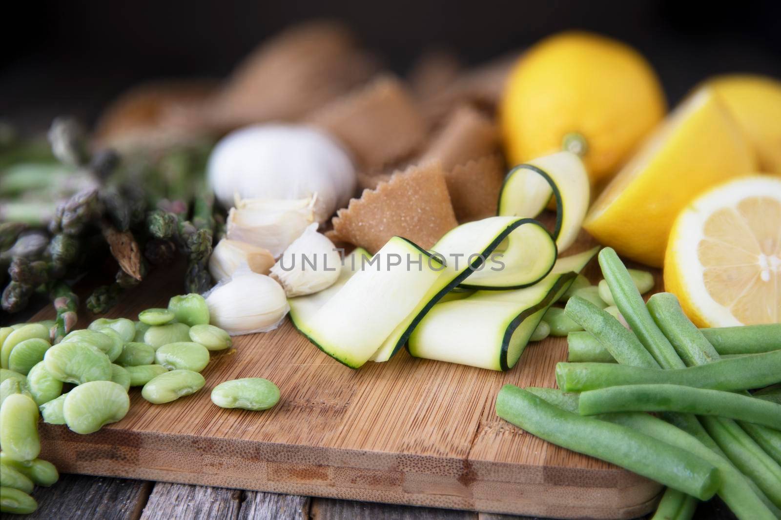 Fresh ingredients for pasta, zucchini, lima beans, green beans, lemon, garlic and homemade whole wheat pappardelle pasta.