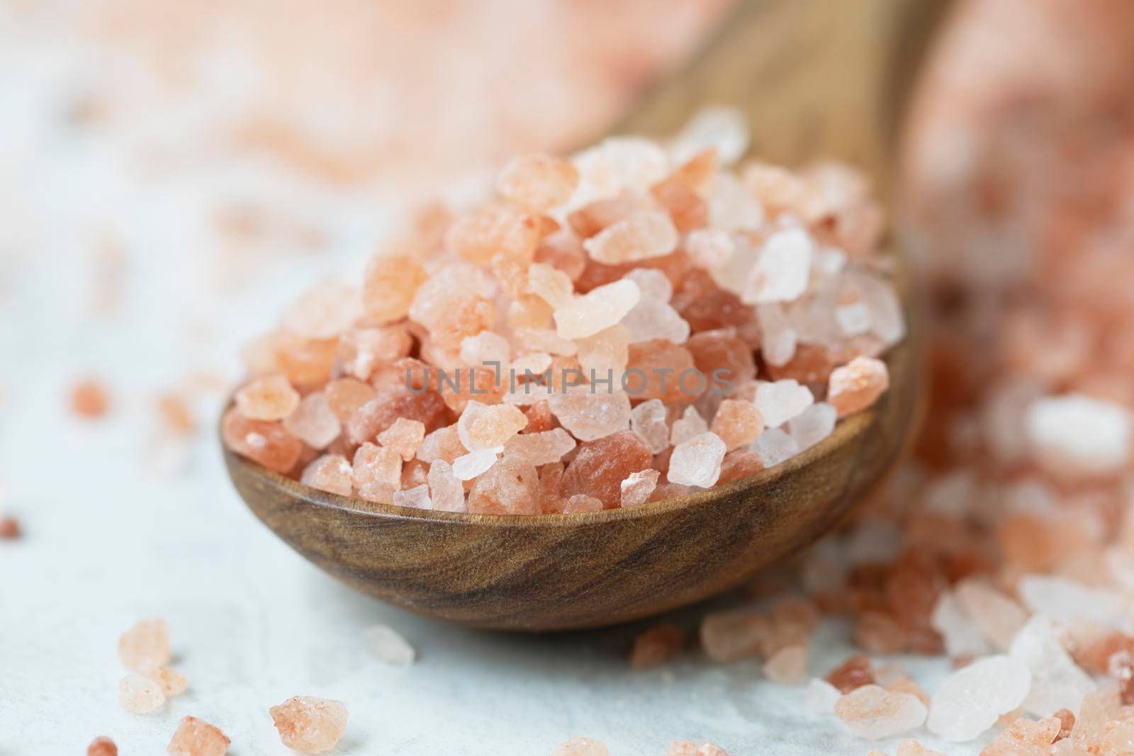 Pink Himalyan salt in wooden spoon, flat lay