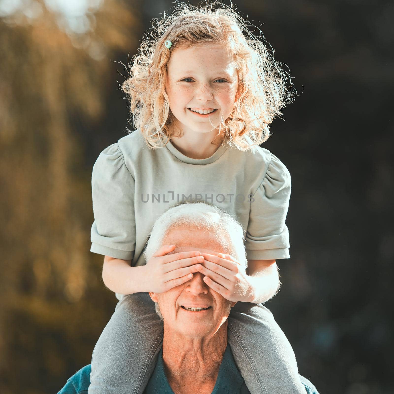 Little girls are the nicest things that happen to people. Shot of a girl being carried by her grandfather outside. by YuriArcurs