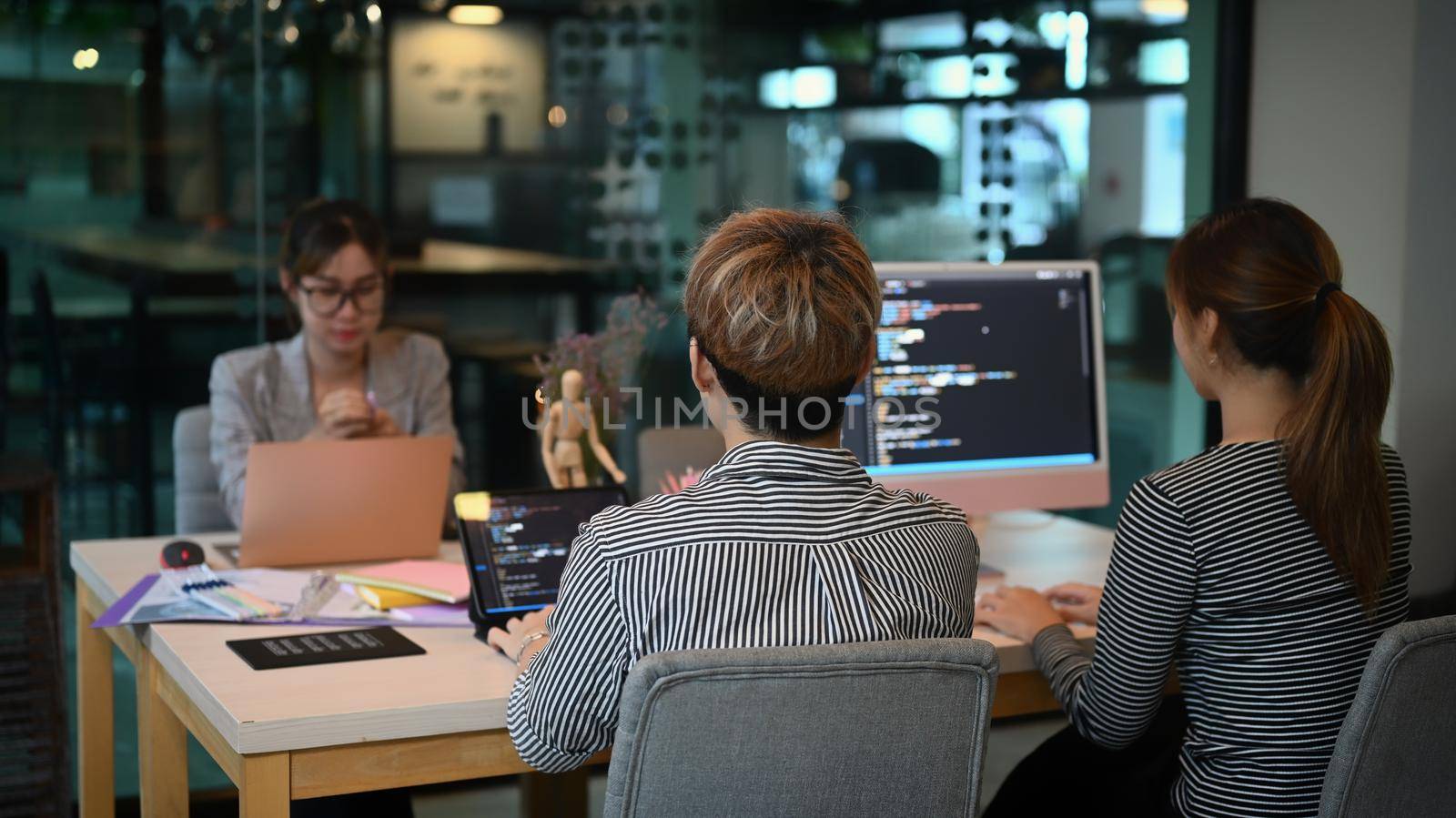 Software developers team brainstorming and programming in co working space by prathanchorruangsak