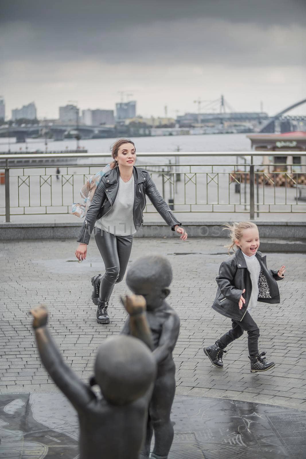 mother plays with her daughter in the city