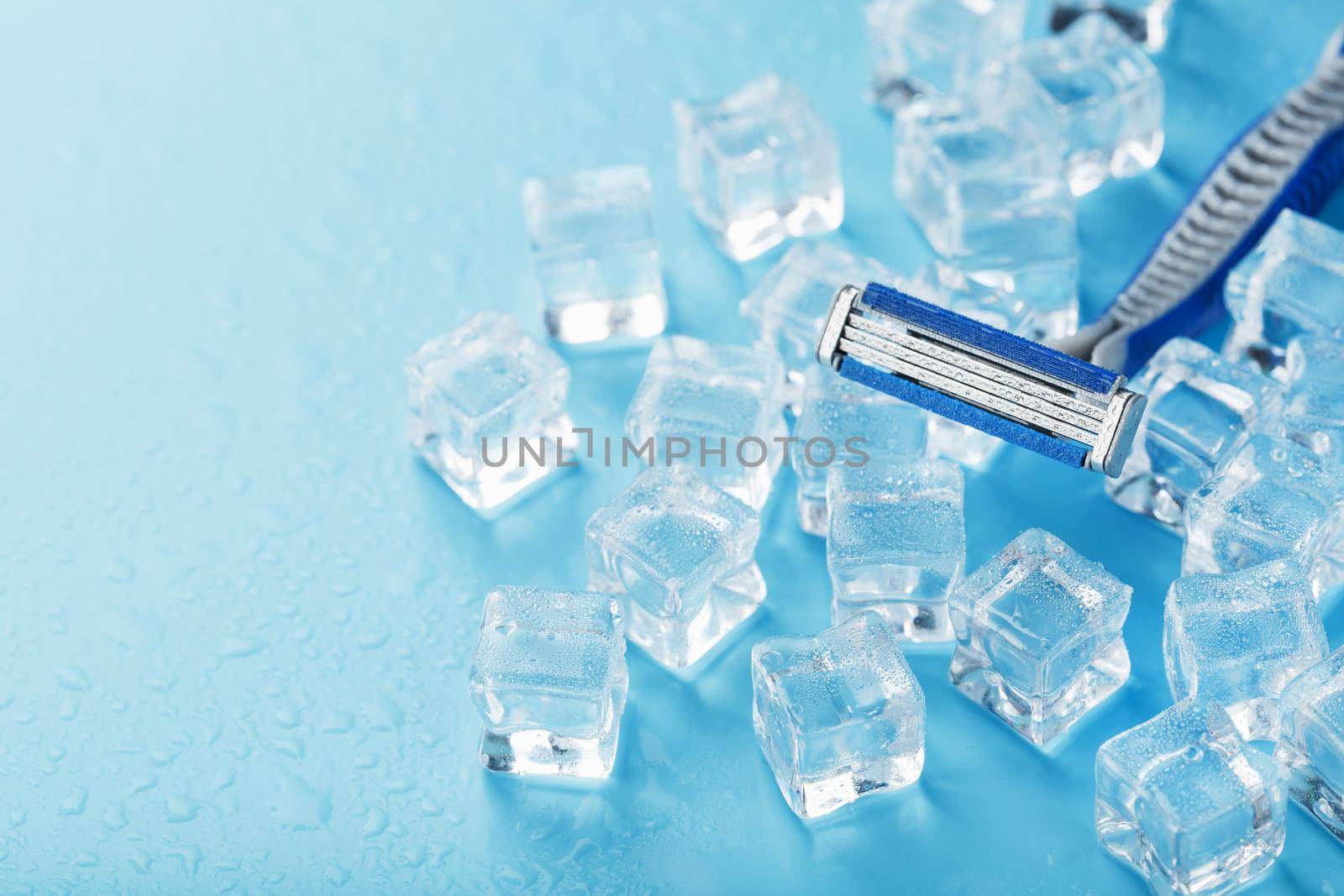 Blue shaving machine with sharp blades on the background of ice cubes close-up by AlexGrec