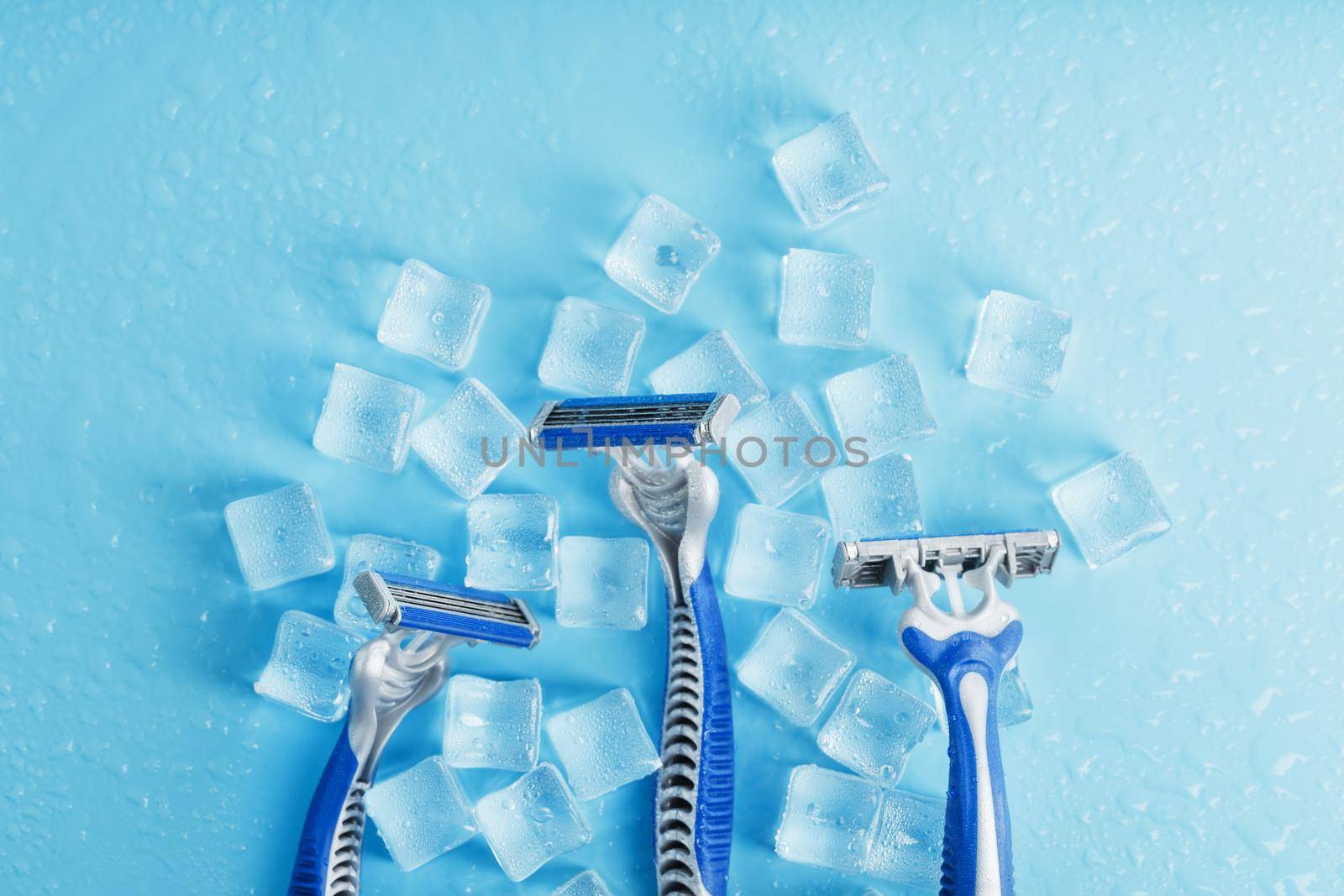 Three shaving machines on a frosty blue background with ice. The concept of cleanliness and frosty freshness by AlexGrec