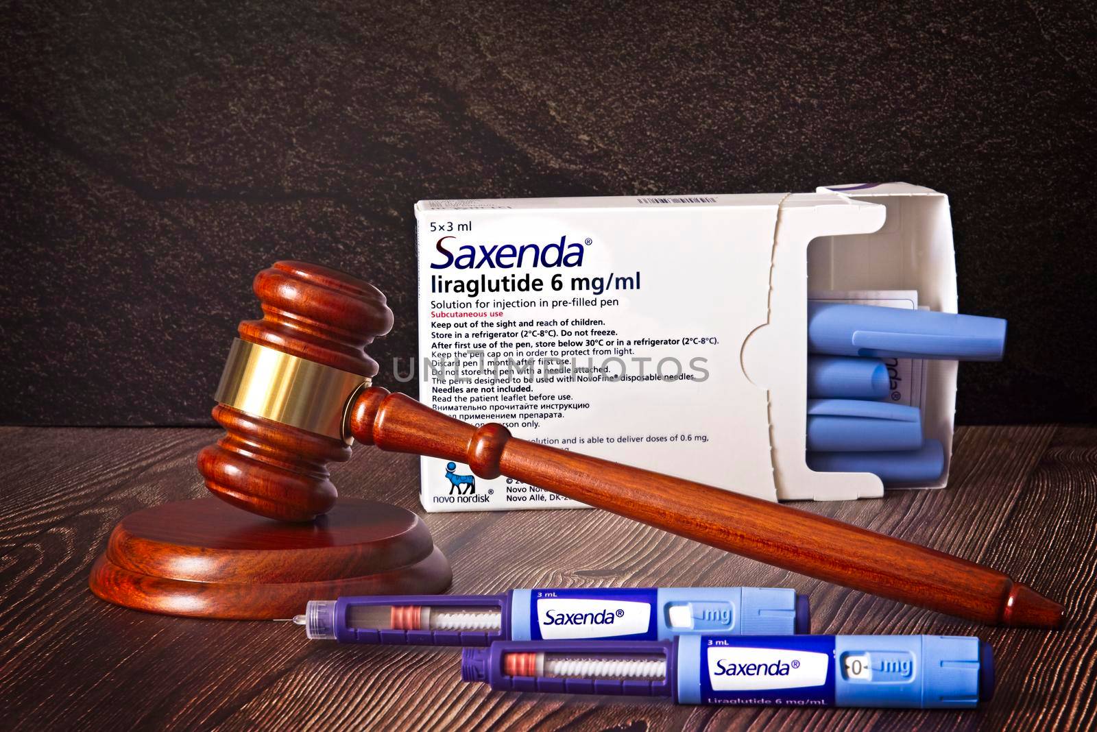 Judges hammer, Saxenda Injection pens on a wooden background. Injections for weight loss, lower blood sugar, and repels hunger. The concept for medical judgment. High quality photo