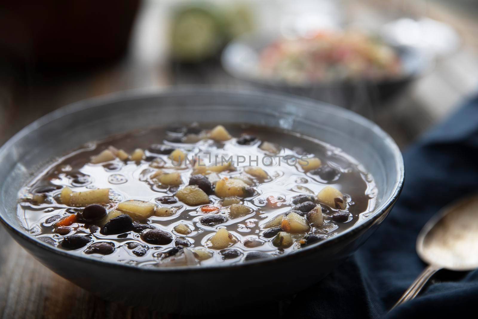 Hearty black bean and potato soup in blue bowl