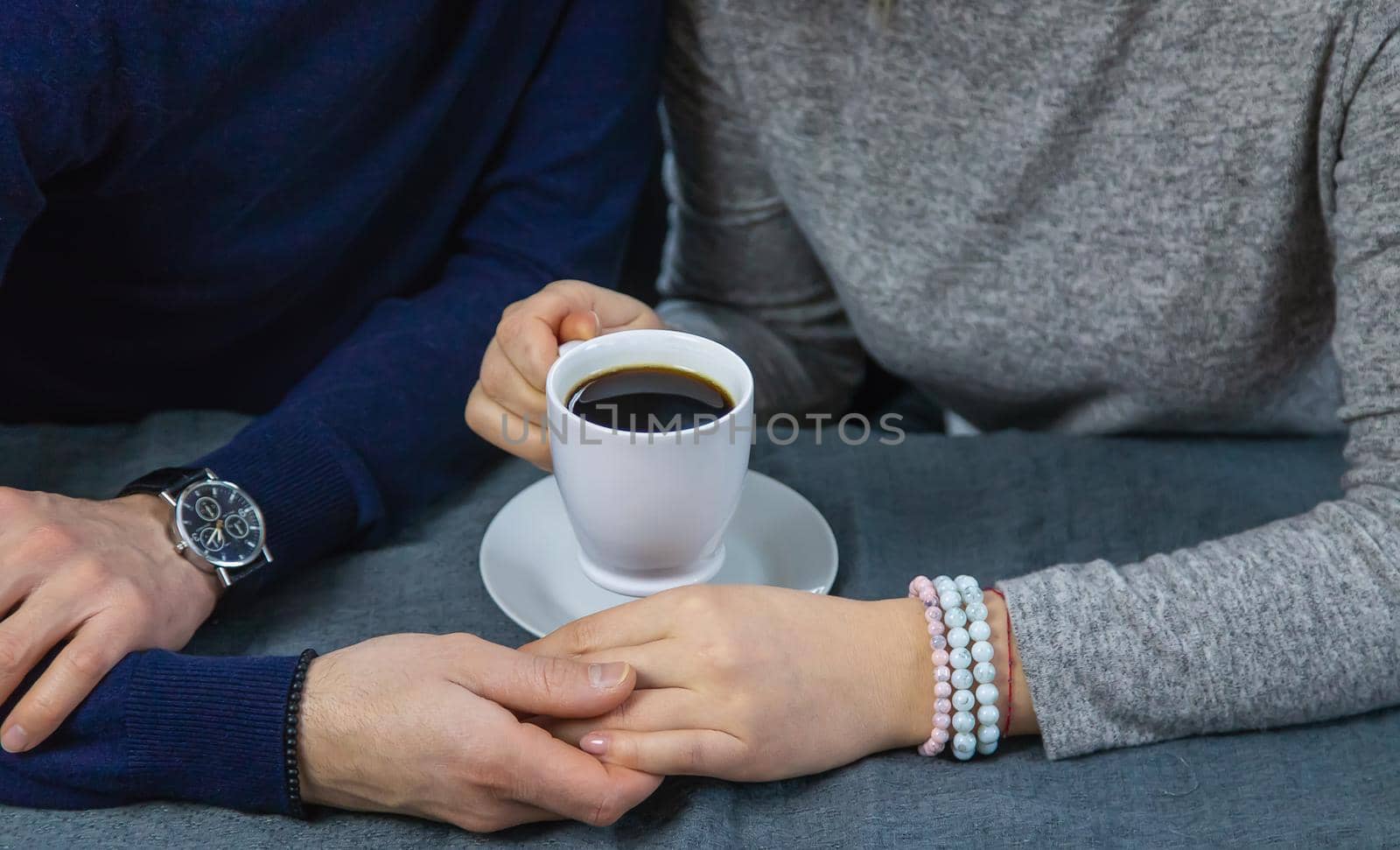 Man and woman at the table with a cup of coffee. Selective focus. by yanadjana