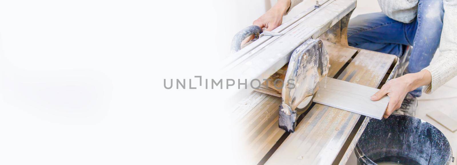 cut tiles with a tile cutter repair in the house. Selective focus. by yanadjana