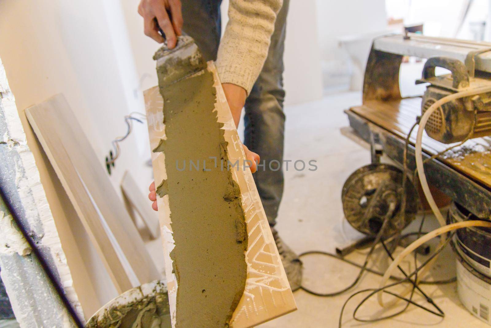 smear the tile repair in the house with a solution. Selective focus. white.