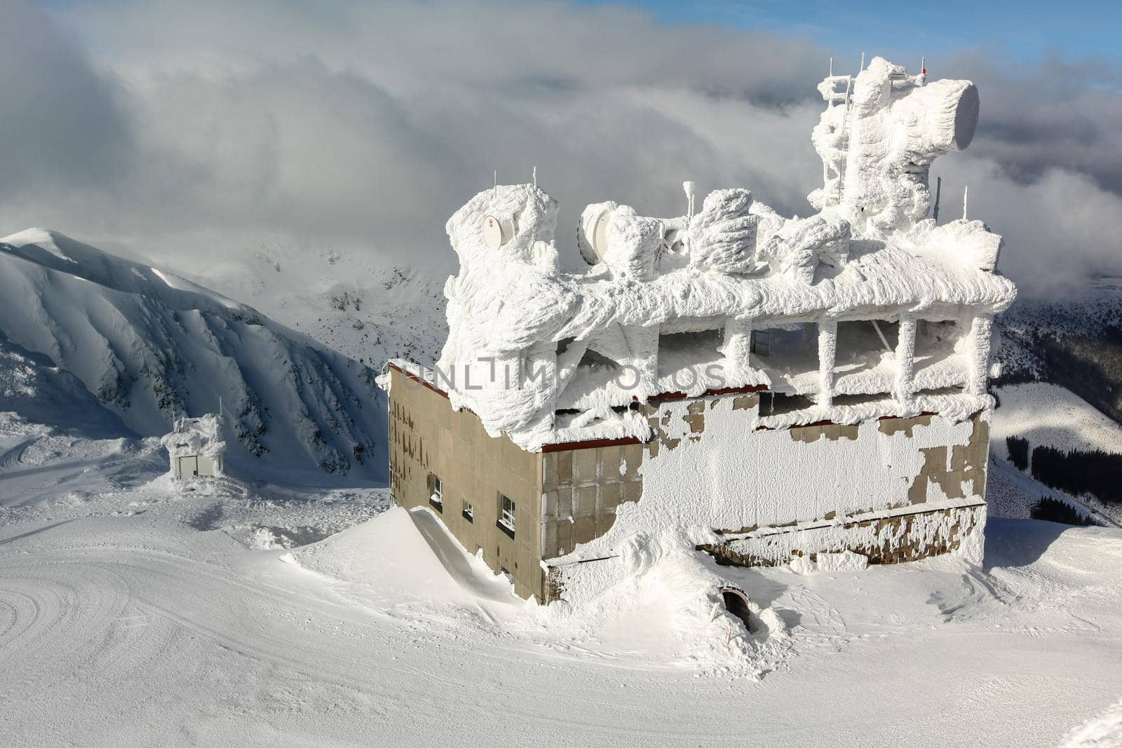 Jasna, Slovakia - January 18, 2018:  Ski lift building, with antennas on roof, top of Chopok moutain, completely covered with snow. Strong wind and snowing is common on Nizke Tatry peaks in winter.