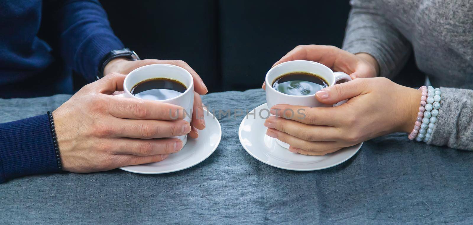 Man and woman at the table with a cup of coffee. Selective focus. People.