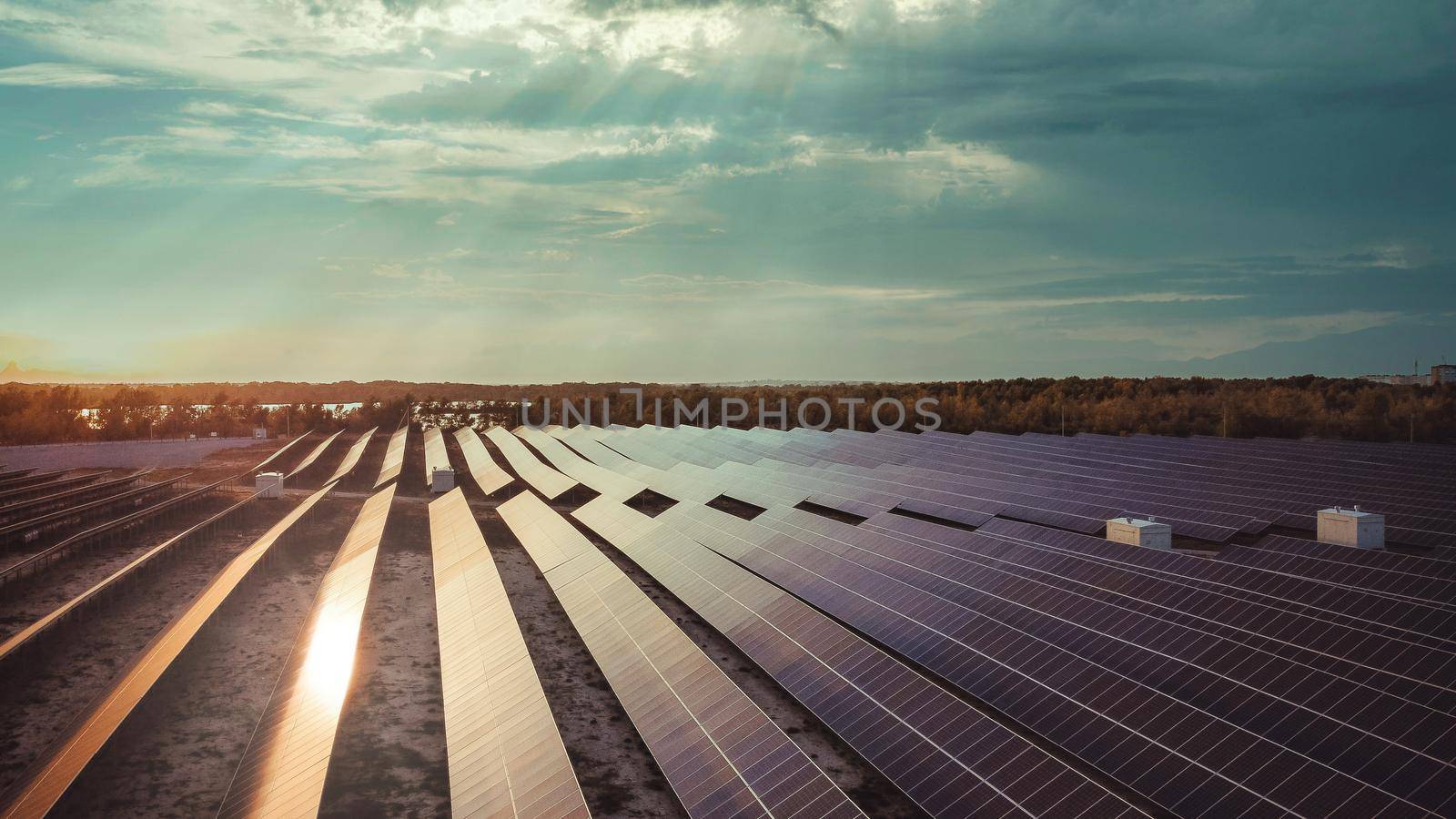 solar panels with the dramatic sky. solar panels with sun reflection. background of photovoltaic modules for renewable energy.