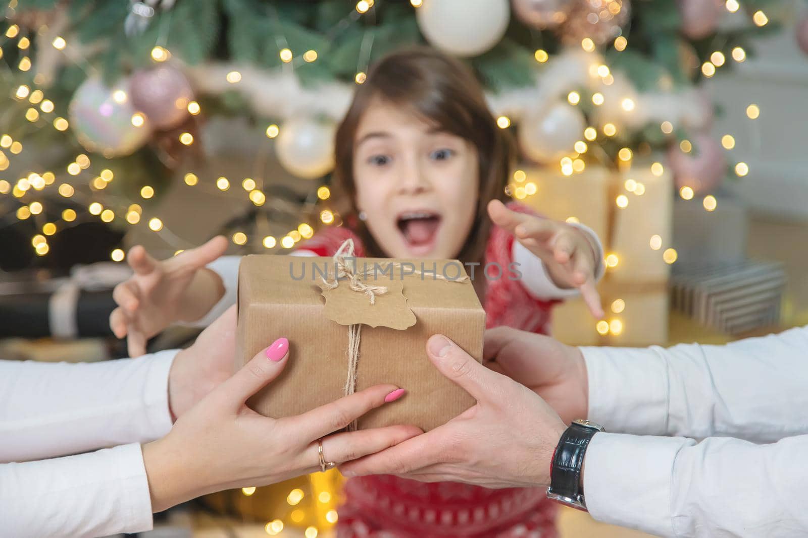 Child girl parents give presents for christmas. Selective focus. Holiday.