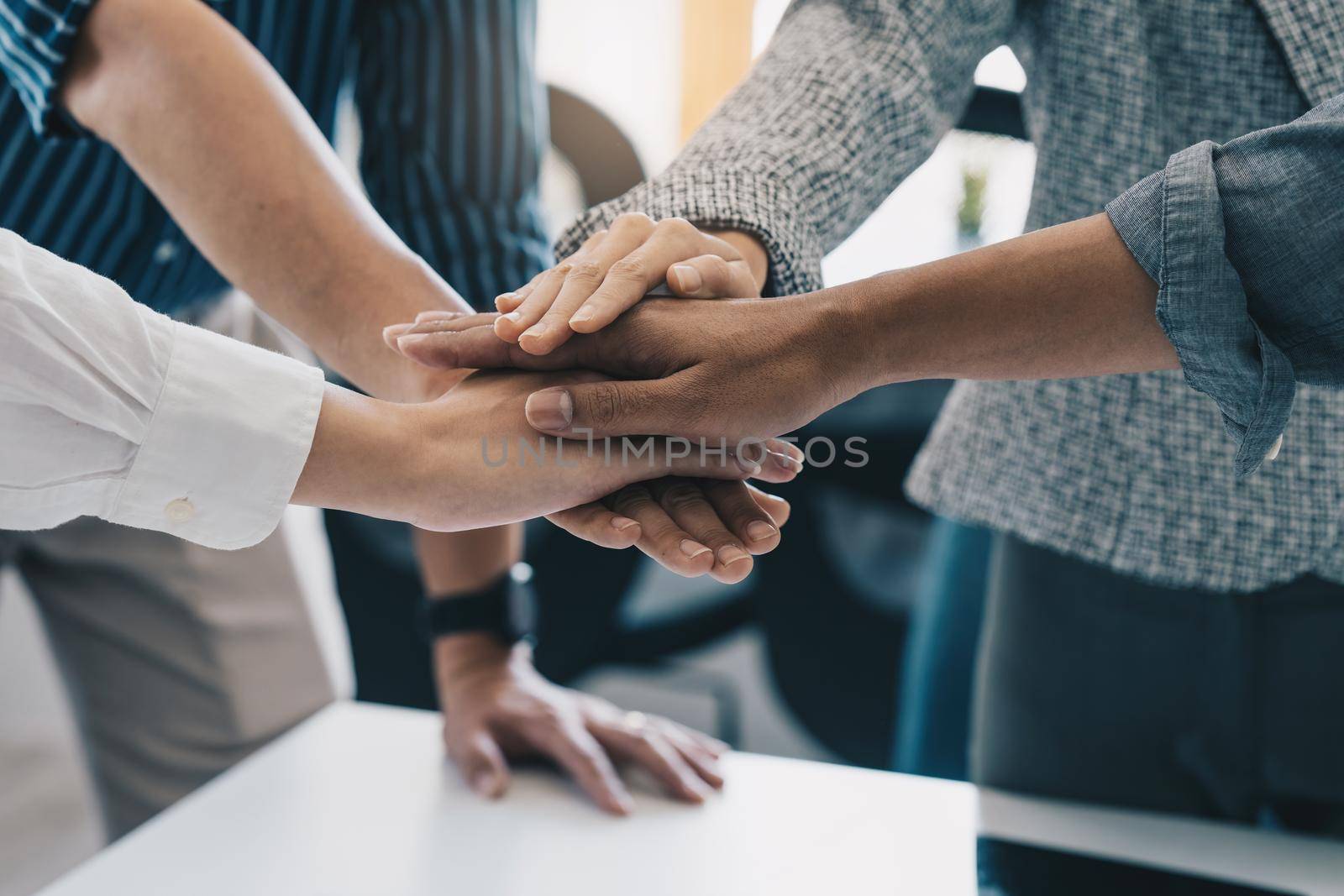 Group of business people putting their hands working together on wooden background in office. group support teamwork agreement concept. by itchaznong