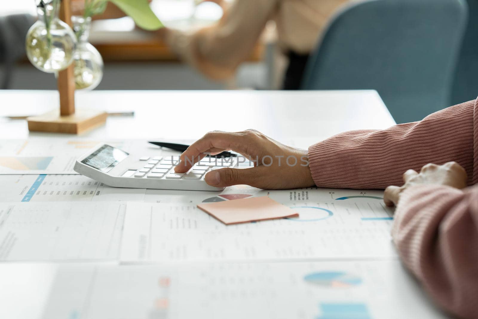Close up Business woman hand using calculator to calculate the company's financial results and budget. Account Audit Concept. by itchaznong