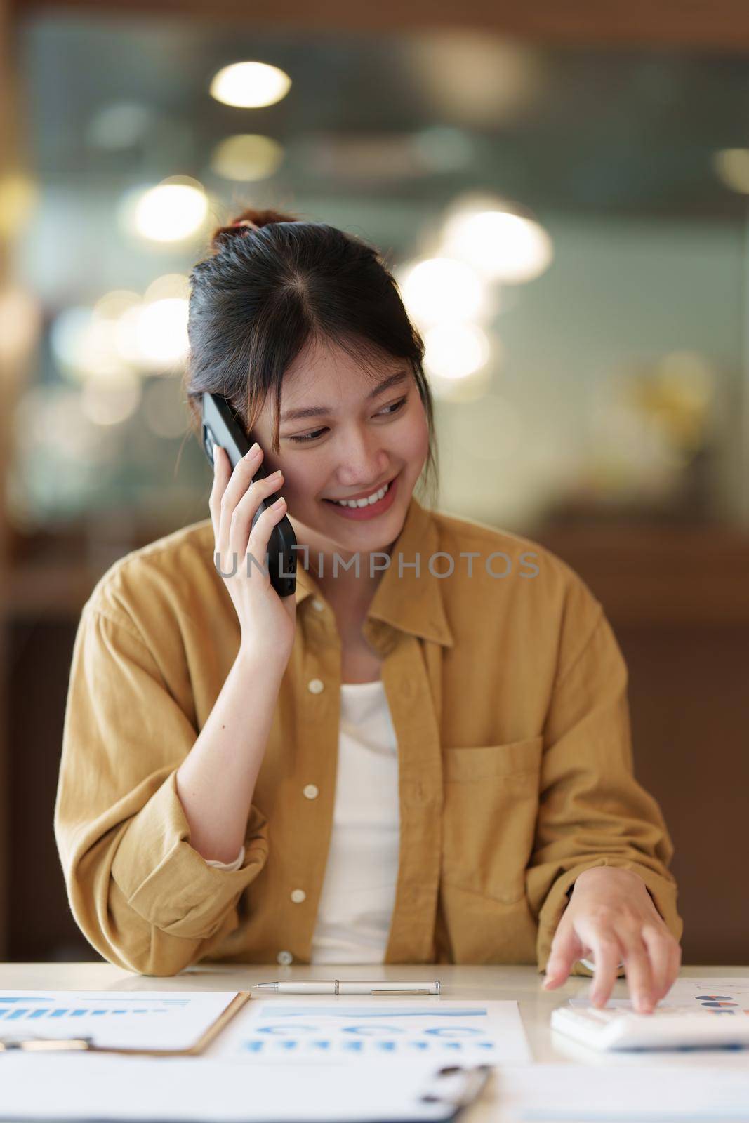 Image of Young woman with a cell phone working online on laptop computer. studying or working from home online concept. by itchaznong