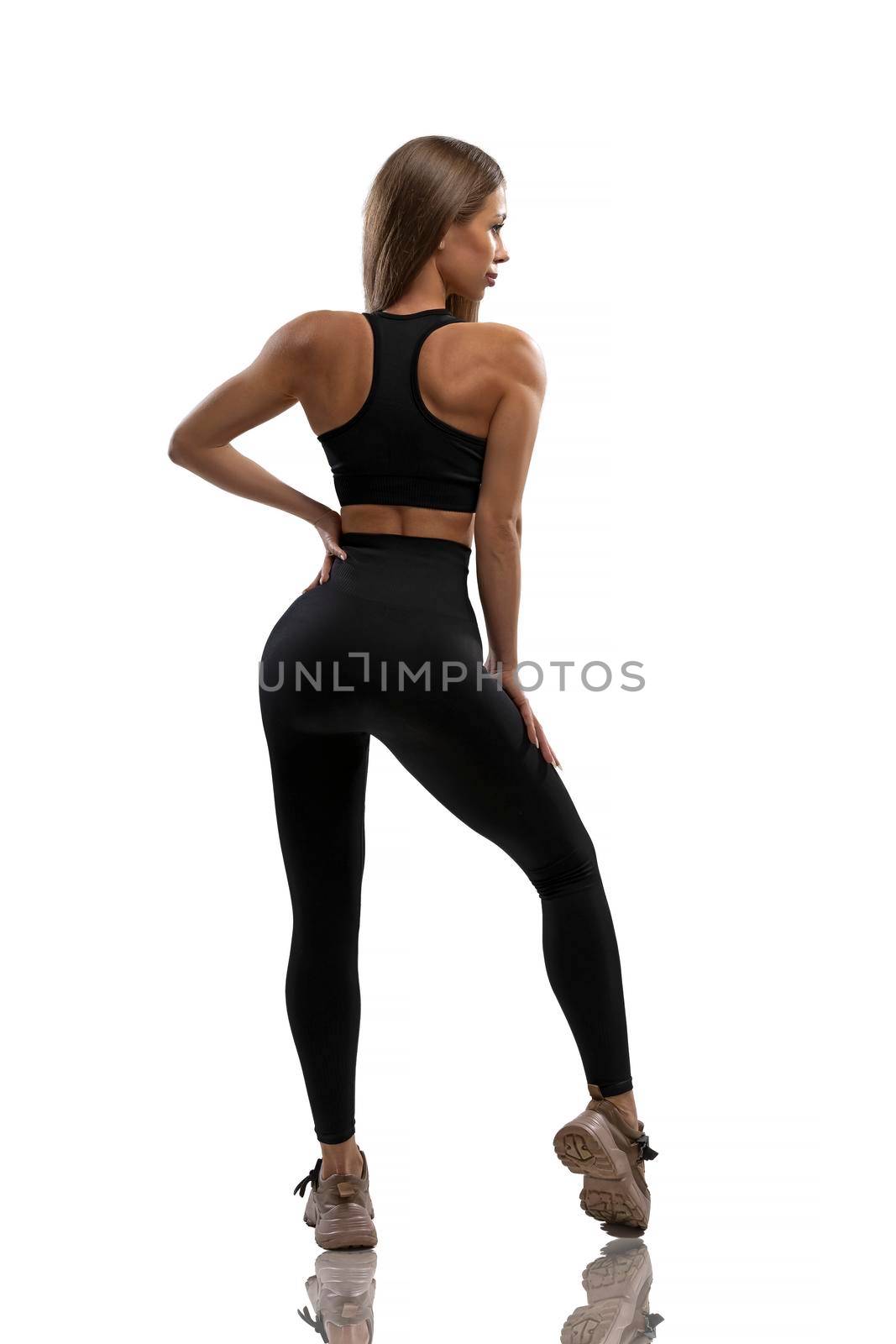 Sexy fit girl in black leggings and top on a white background in the studio by but_photo