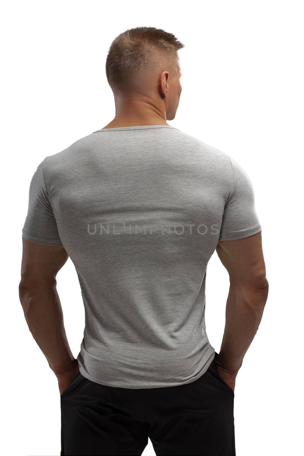 Portrait of an attractive athlete in a grey t-shirt on a white cyclorama in the studio. Sports lifestyle.