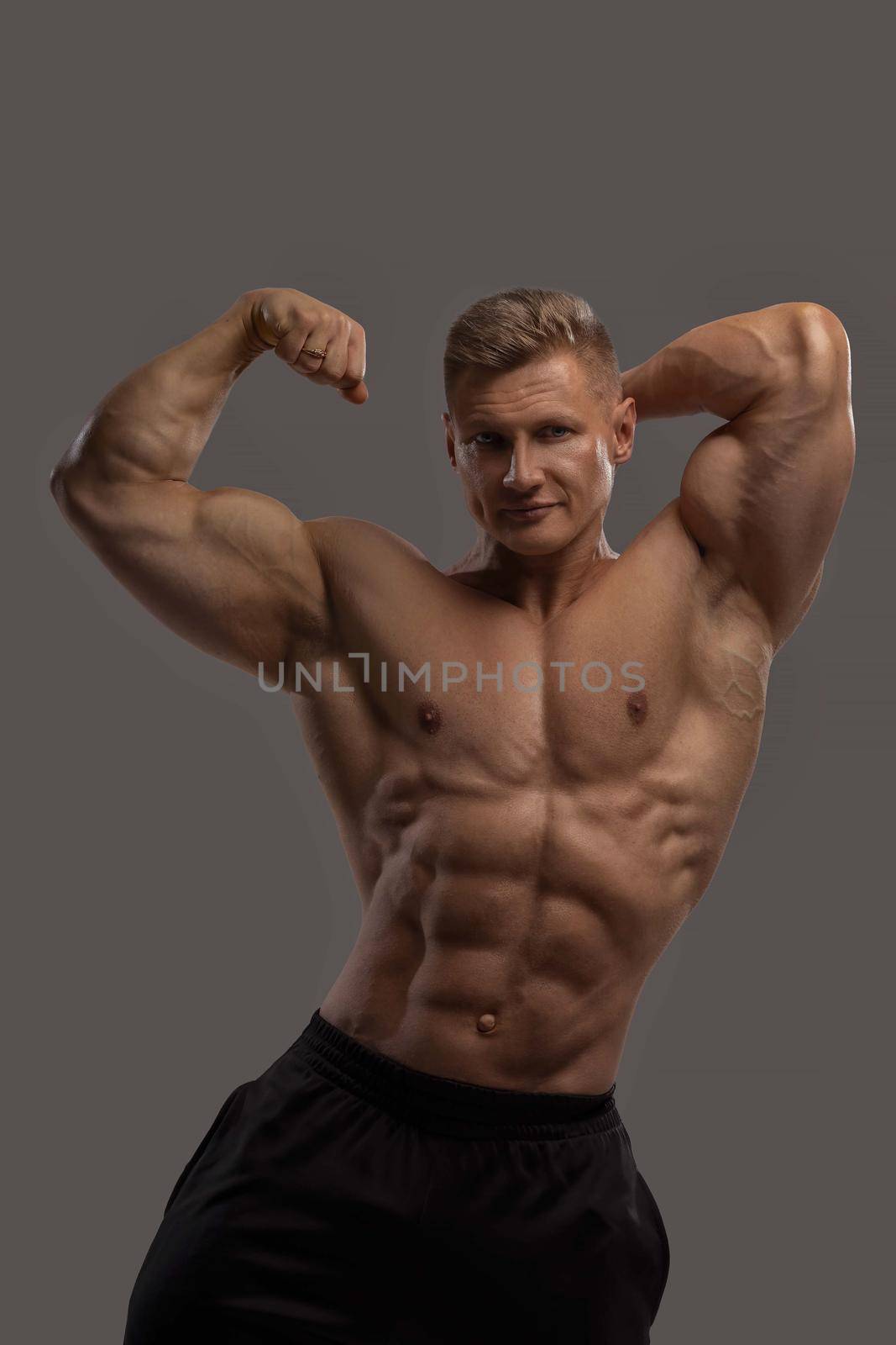 Professional bodybuilder in a dry filled form in a large weight category posing on a black background. Sports lifestyle.