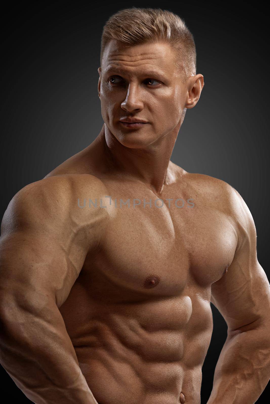 Professional bodybuilder in a dry filled form in a large weight category posing on a black background. Sports lifestyle.