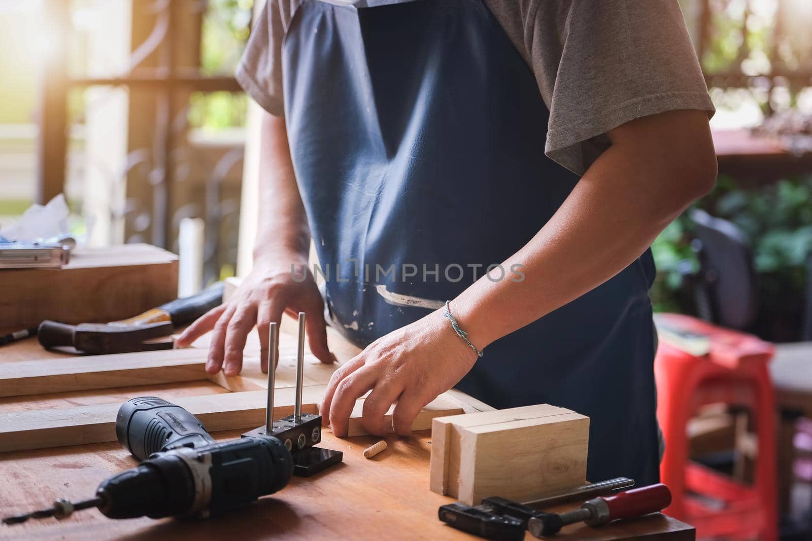 Entrepreneur Woodwork measures the planks to assemble the parts and build a wooden table for the customer