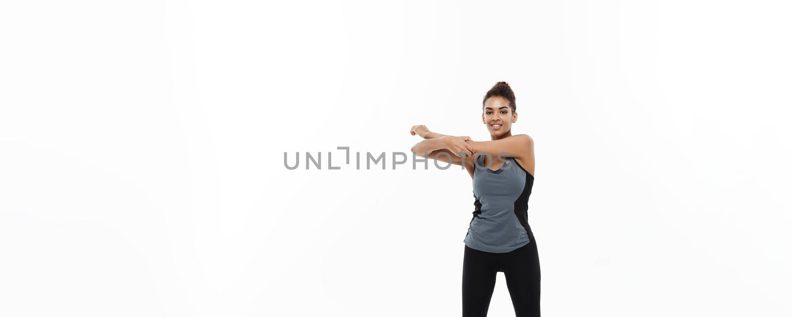 Sport, training, lifestyle and Fitness concept - Full-length portrait of beautiful happy African American woman stretching hands. Isolated on white studio background