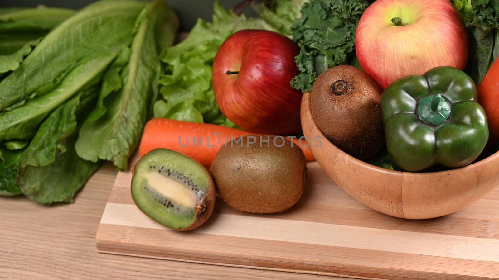 Assorted vegetables and fruits on wooden background.