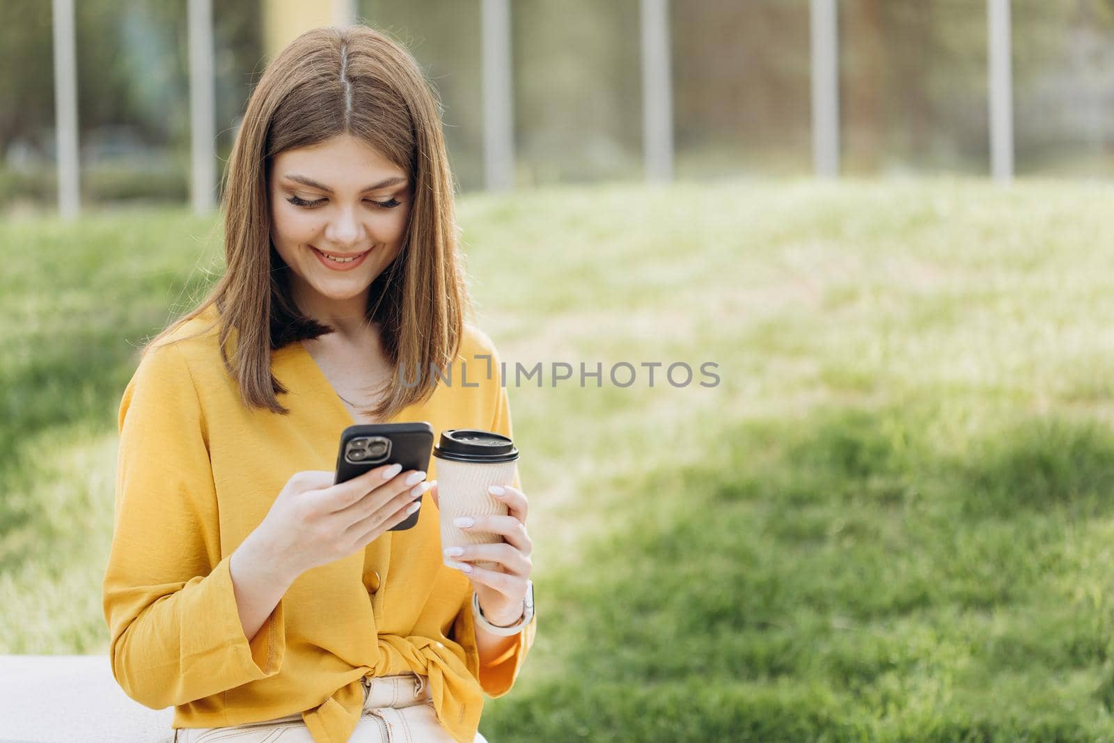 Happy businesswoman using mobile phone at remote workplace. Smiling woman browsing internet on smartphone near office. Portrait of business woman reading messages on cellphone by uflypro