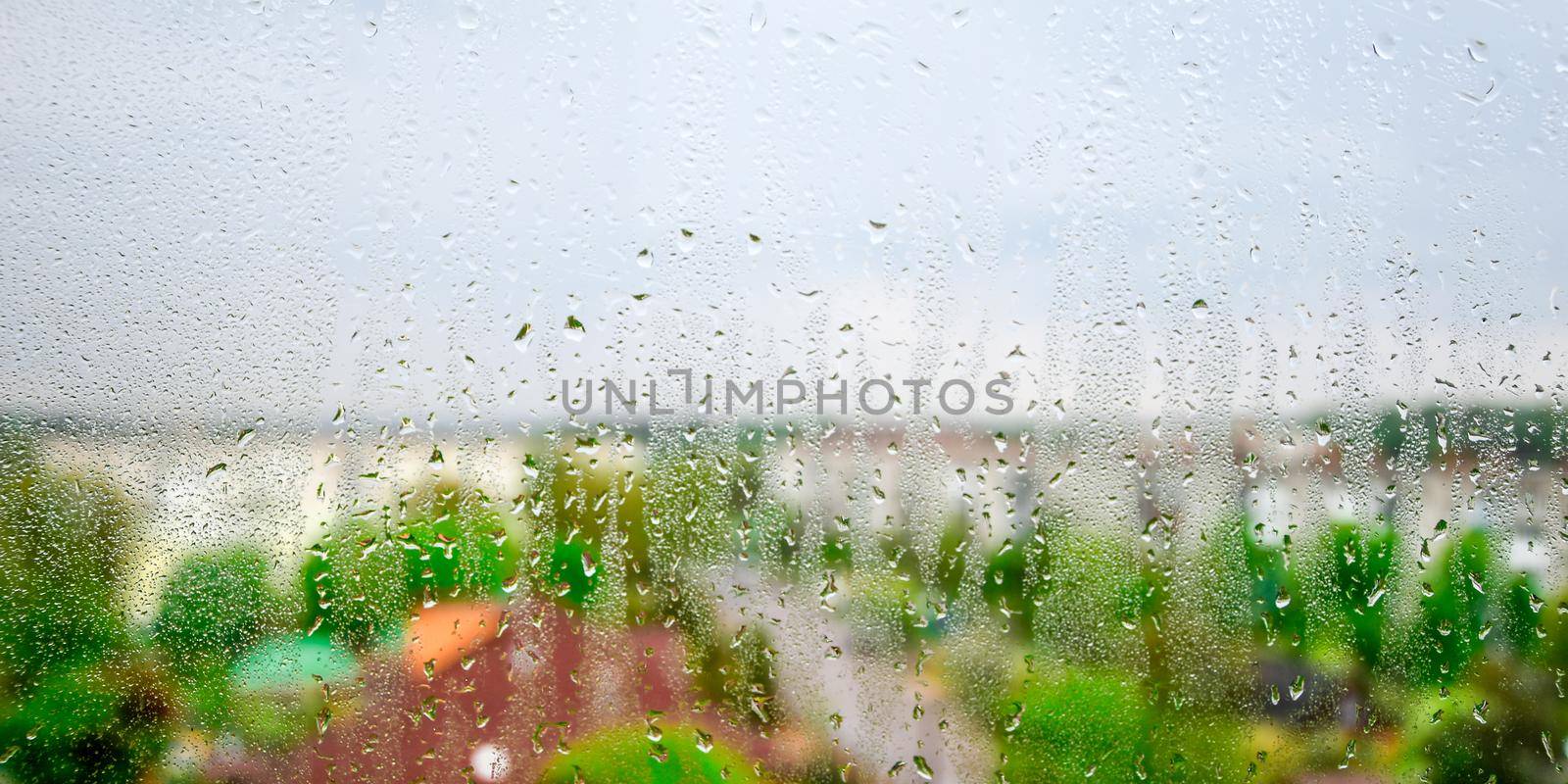 Raindrops on the window glass Looking Out Through the Window Listening to the Rain, copy space, selective focus