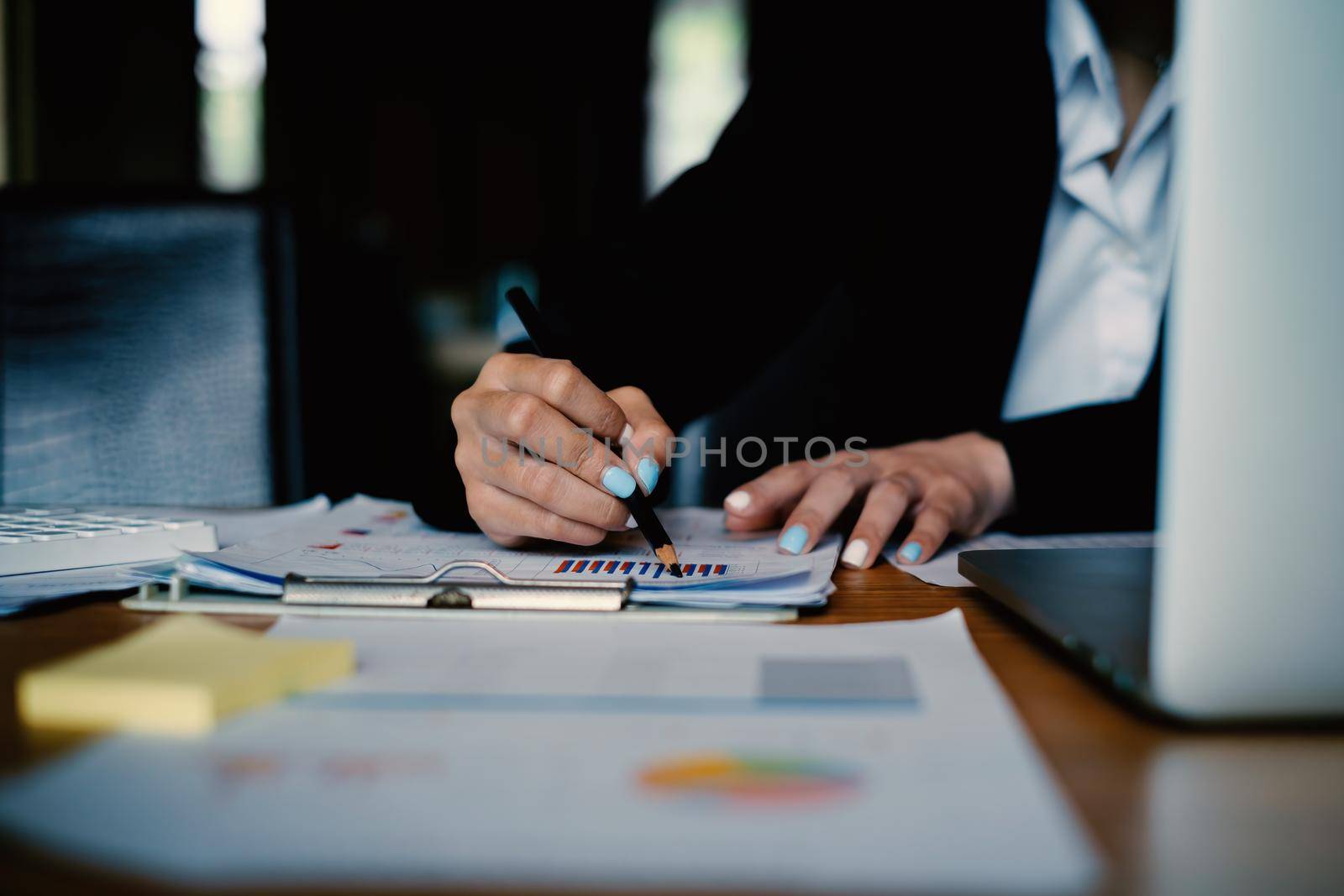 A businesswoman examines a financial chart in order to make arrangements. Investment concept for a business fund. by itchaznong