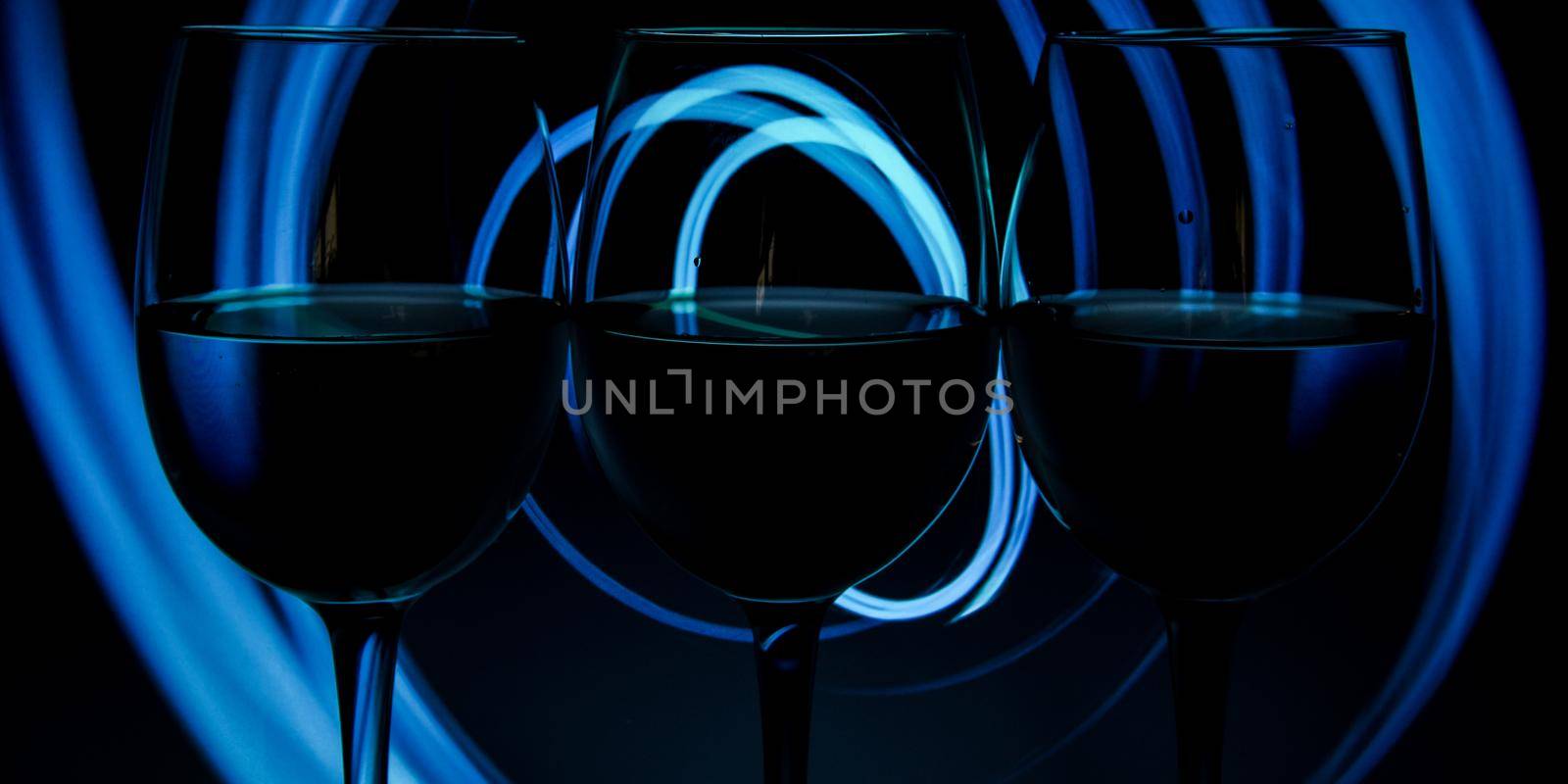 Three wine glasses in a row with dark light painting behind, Set of three wine glasses with red, white and rose wine, banner, alcohol drinks