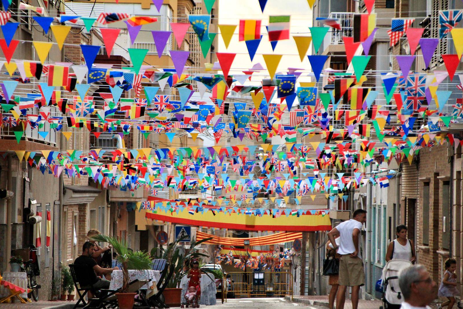 Santa Pola, Alicante, Spain- September 3, 2019: Street of Santa Pola decked out with colored flags and garlands for its festivities in September.