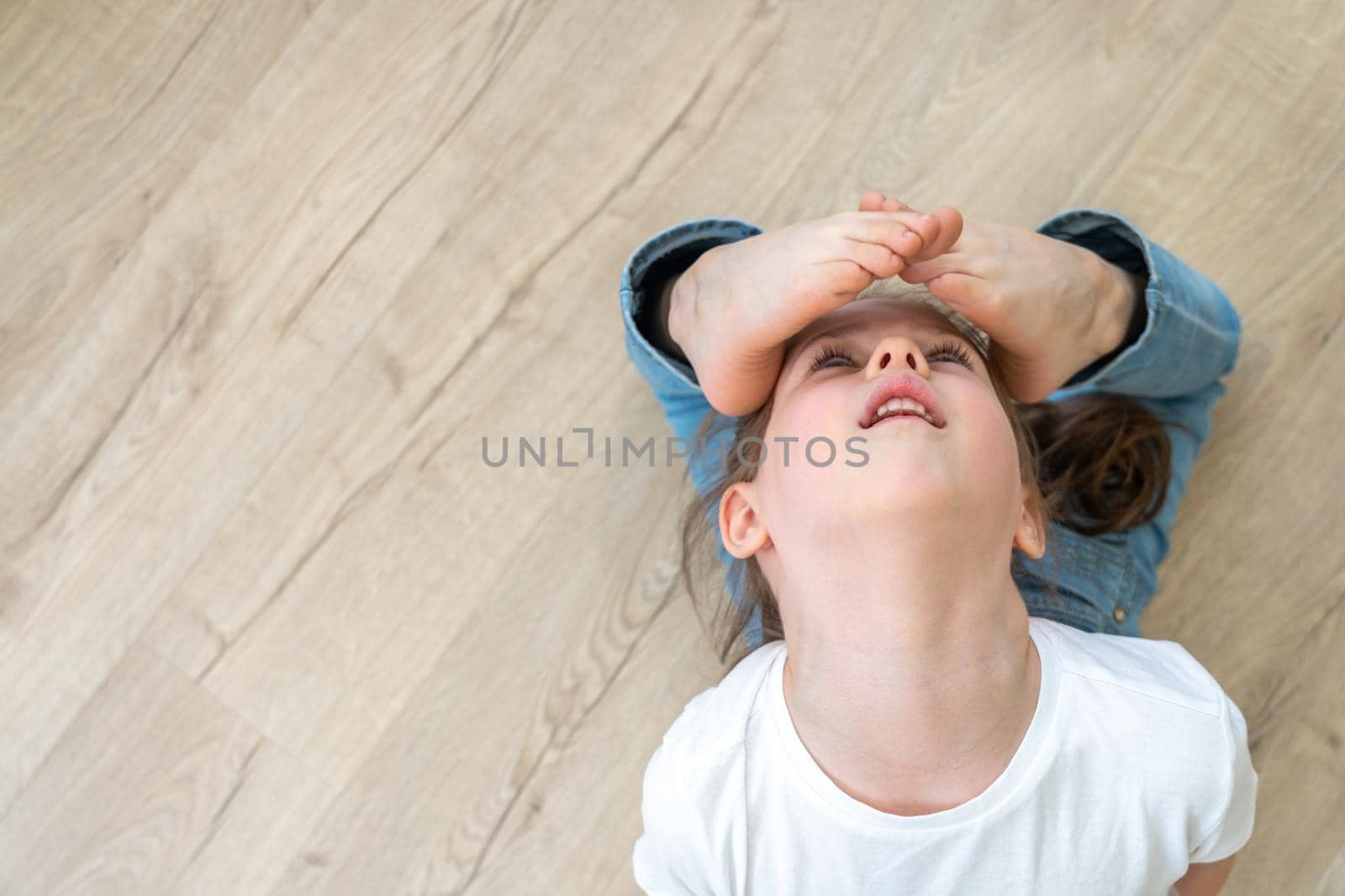 Pretty flexible girl making gymnastic trick. View from above