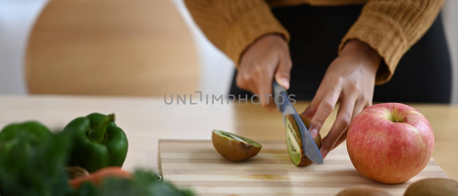 Vegetarian woman preparing healthy vegan food in kitchen. Healthy lifestyle concept.