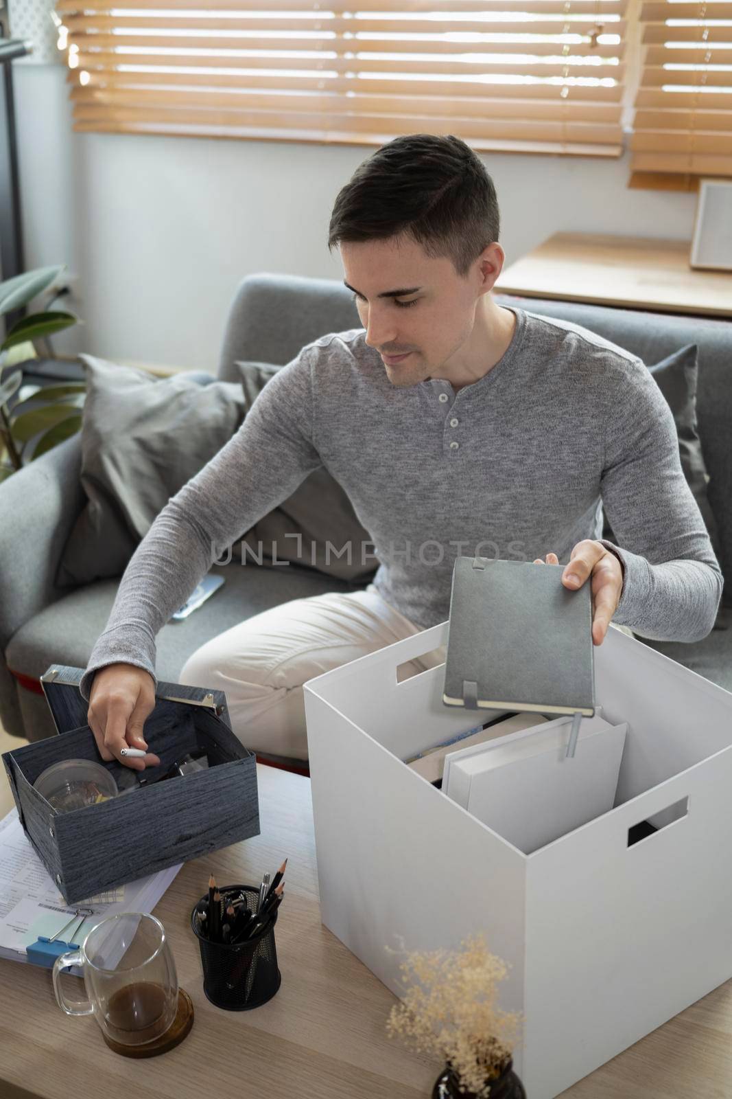 Young man preparing personal stuff for moving into new house.
