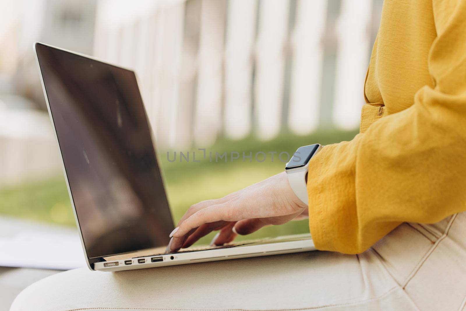 Hands of unrecognizable girl working outside at modern office on background. Businesswoman hands busy working on laptop computer for send emails and surf on a web browser. Concept of work at computer.