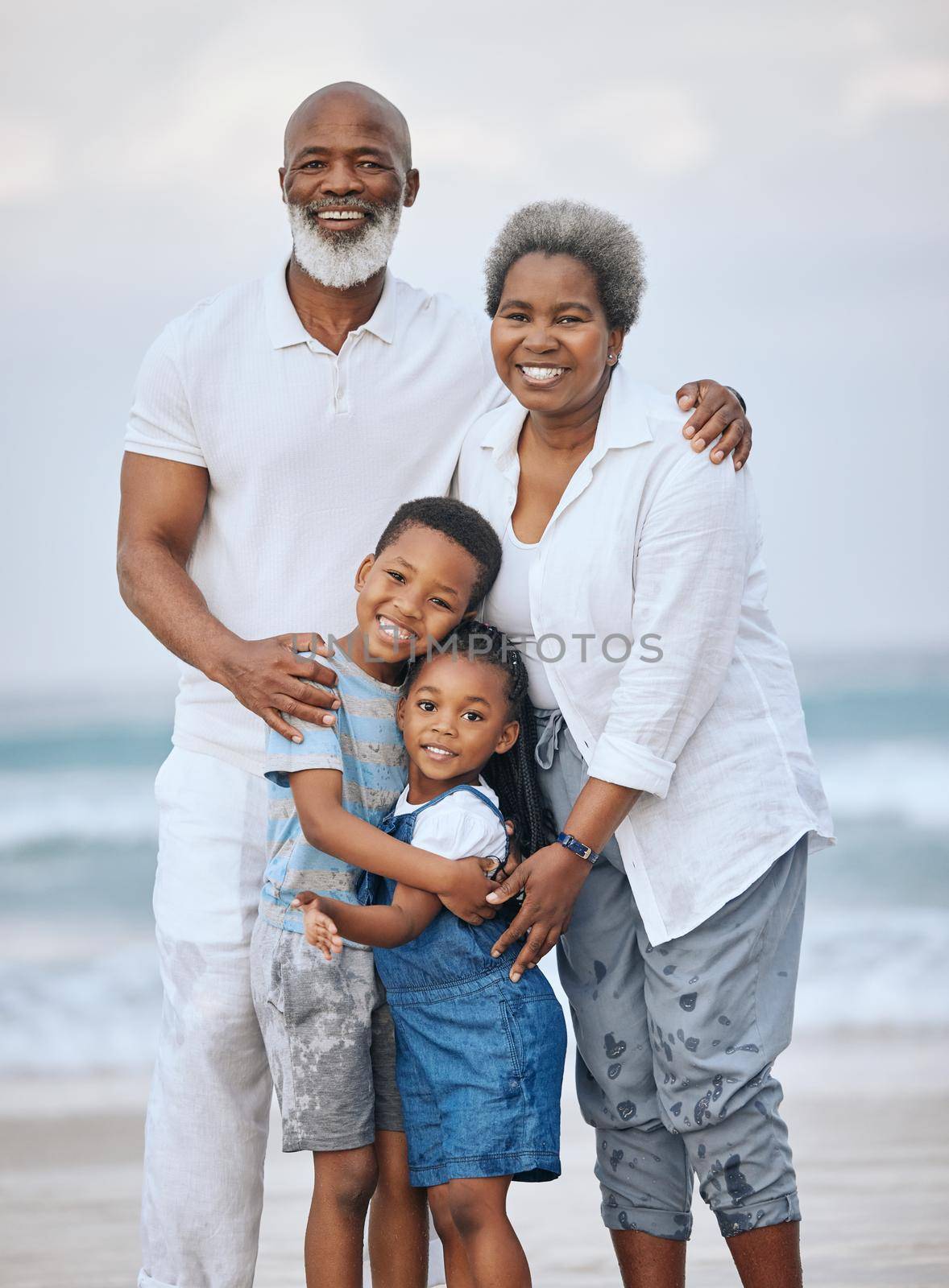 Shot of a mature couple bonding with their grandkids at the beach.