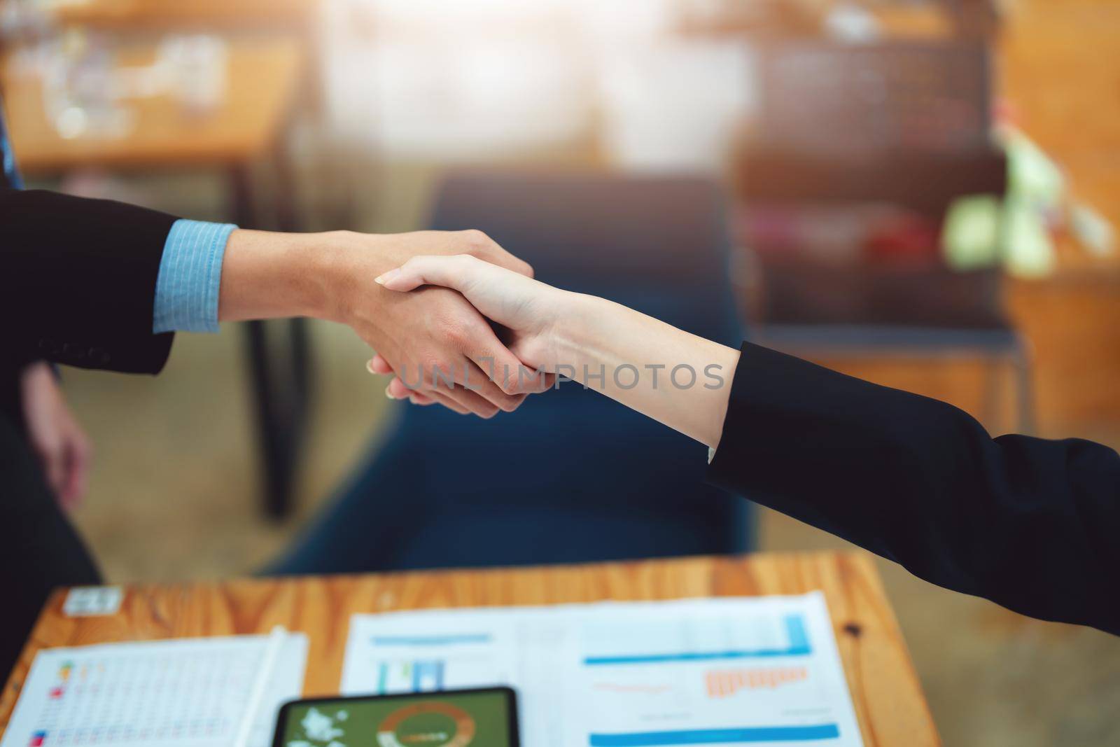 Asian entrepreneurs handshakes to congratulate the agreement between the two companies to enhance investment and financial strength. deal concept by Manastrong