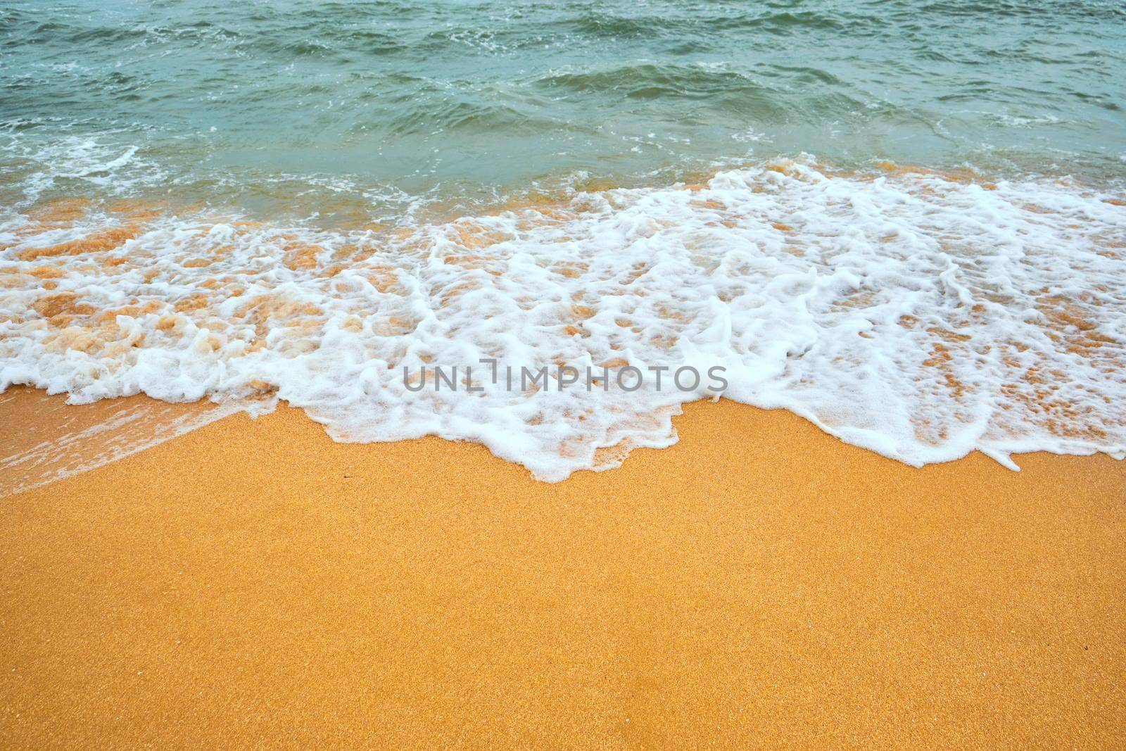 Top view over beach sea. Beautiful sea waves. Beach sand and amazing sea. Summer seascape. Water texture background.