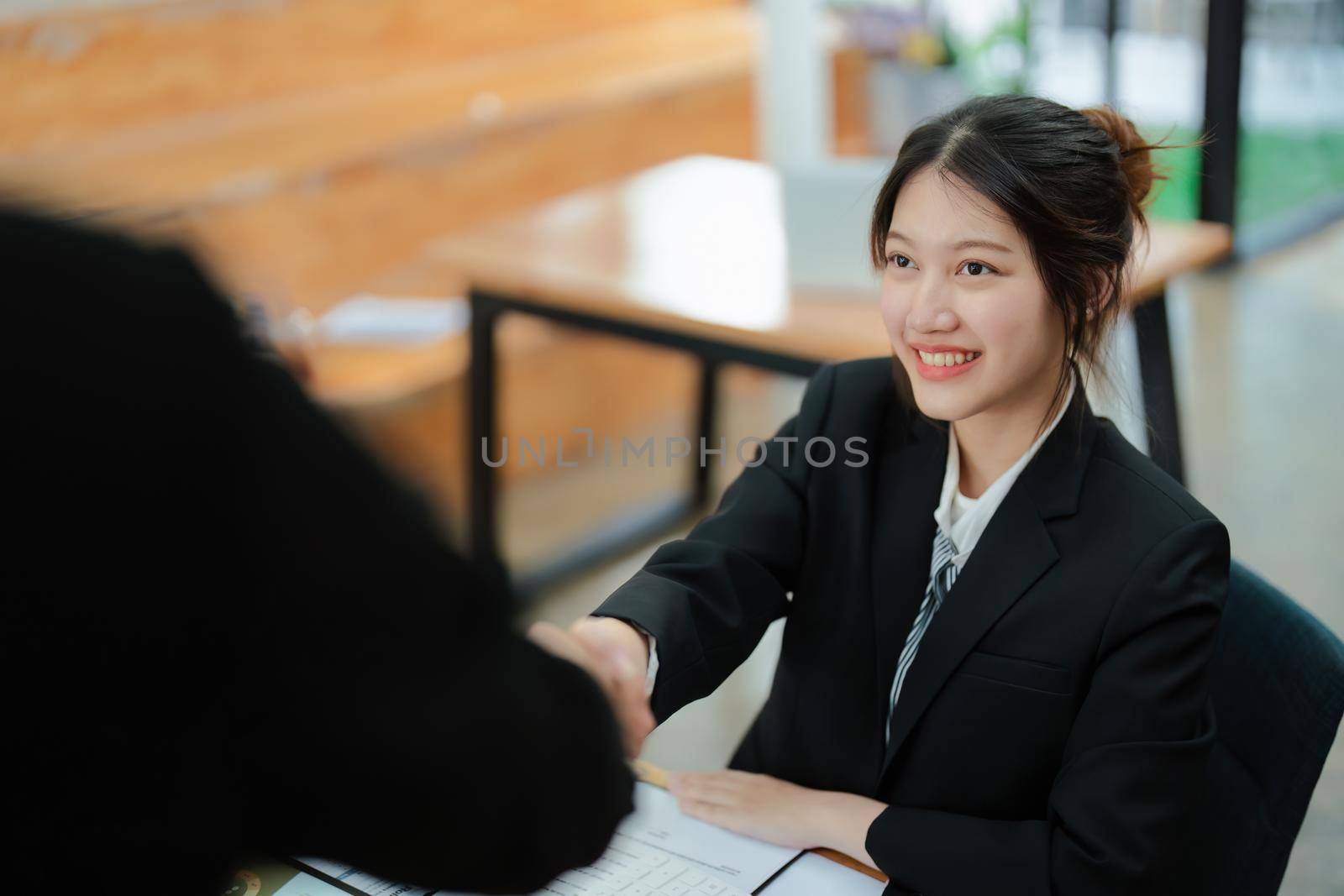 Asian entrepreneurs handshakes to congratulate the agreement between the two companies to enhance investment and financial strength. deal concept by Manastrong