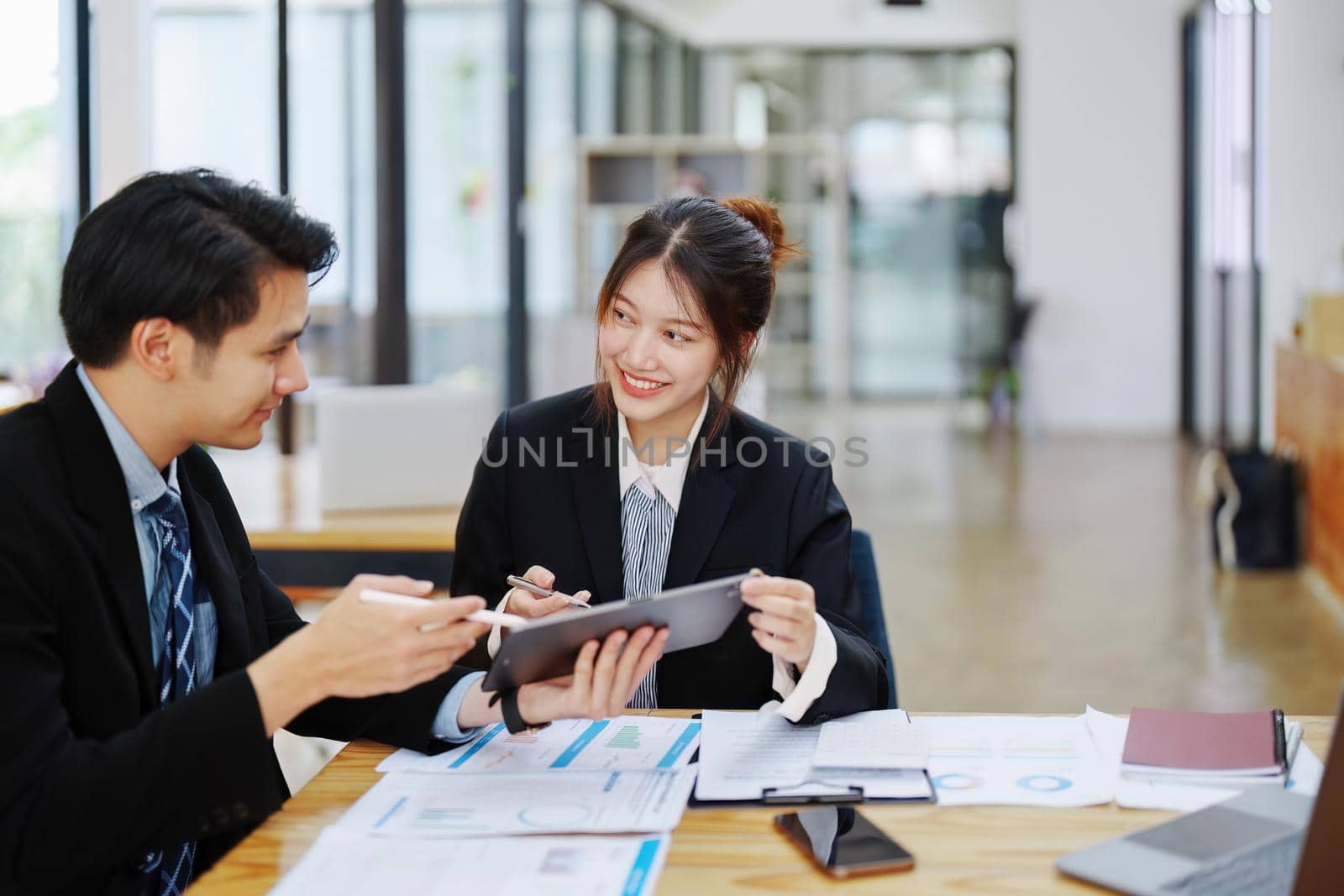 Asian portrait of people working together on a new project to analyze budgets and manage investment risks in today's profit boosting for marketing in the office room.