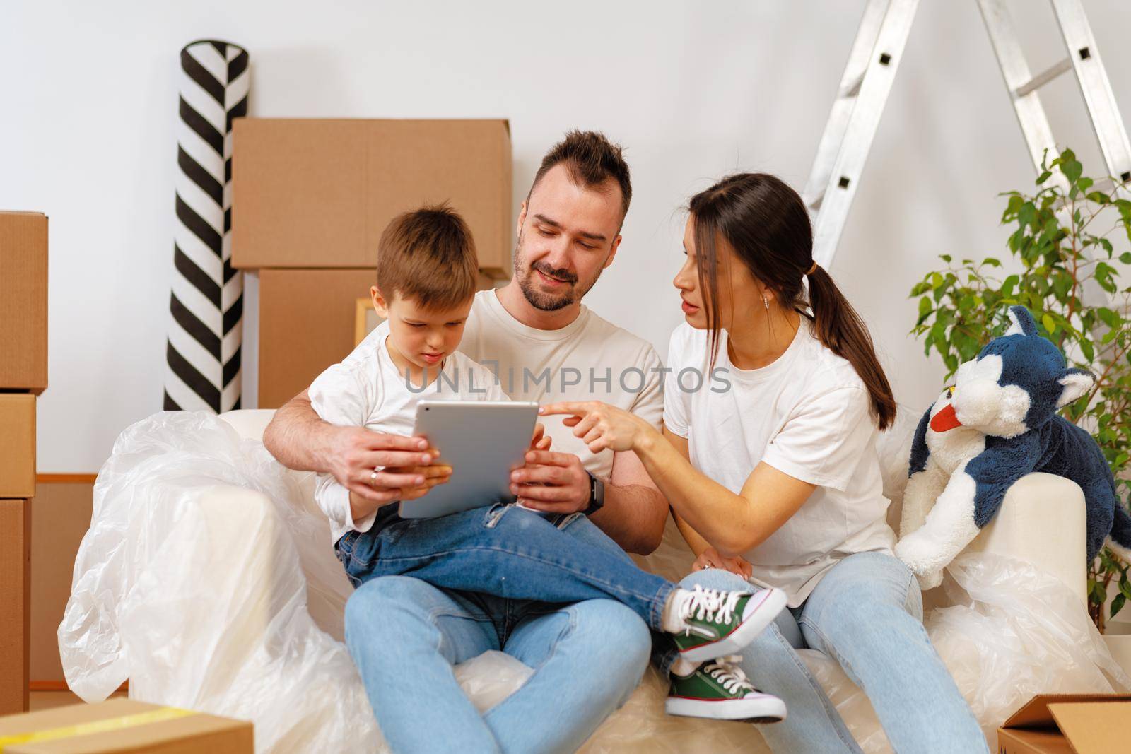 Portrait of happy family with cardboard boxes in new house at moving day, close up