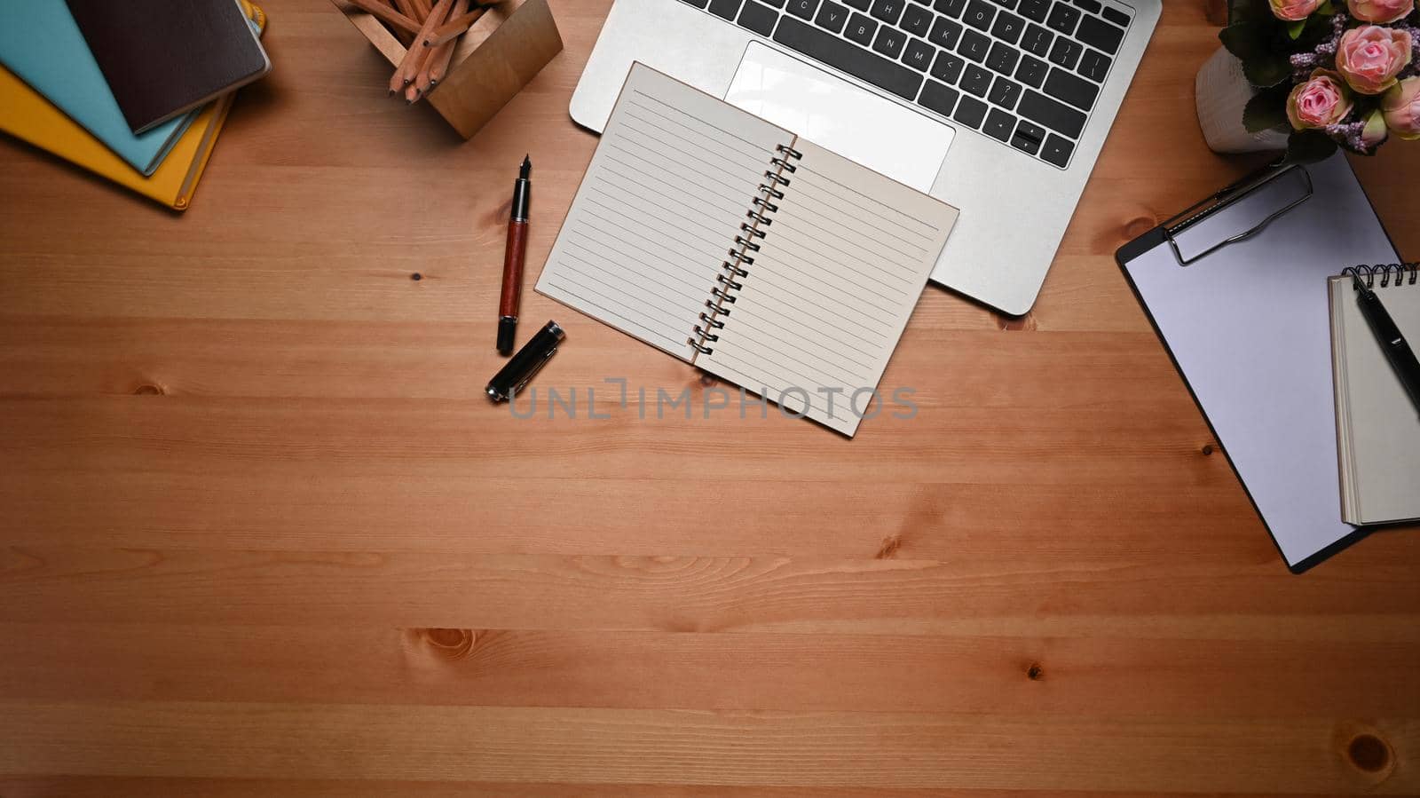 Empty notebook, laptop computer and pencil holder on wooden tale. Flat lay. by prathanchorruangsak