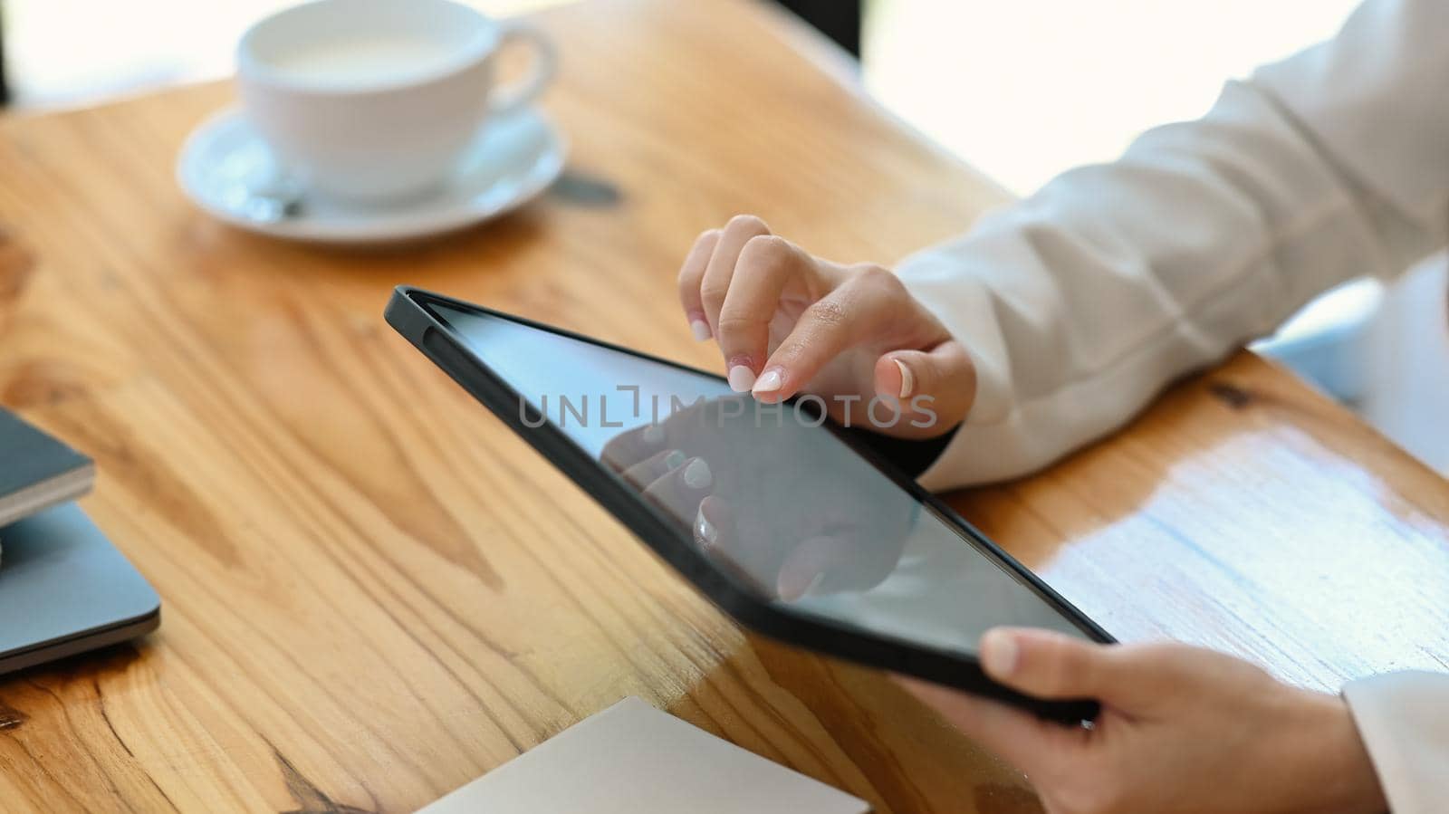 Close up view businesswoman using digital tablet at office desk.