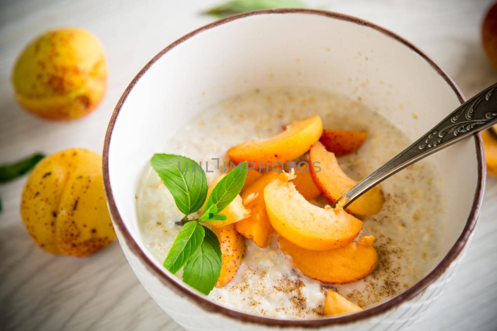 Healthy breakfast of apricot oatmeal with fresh fruit by Rawlik